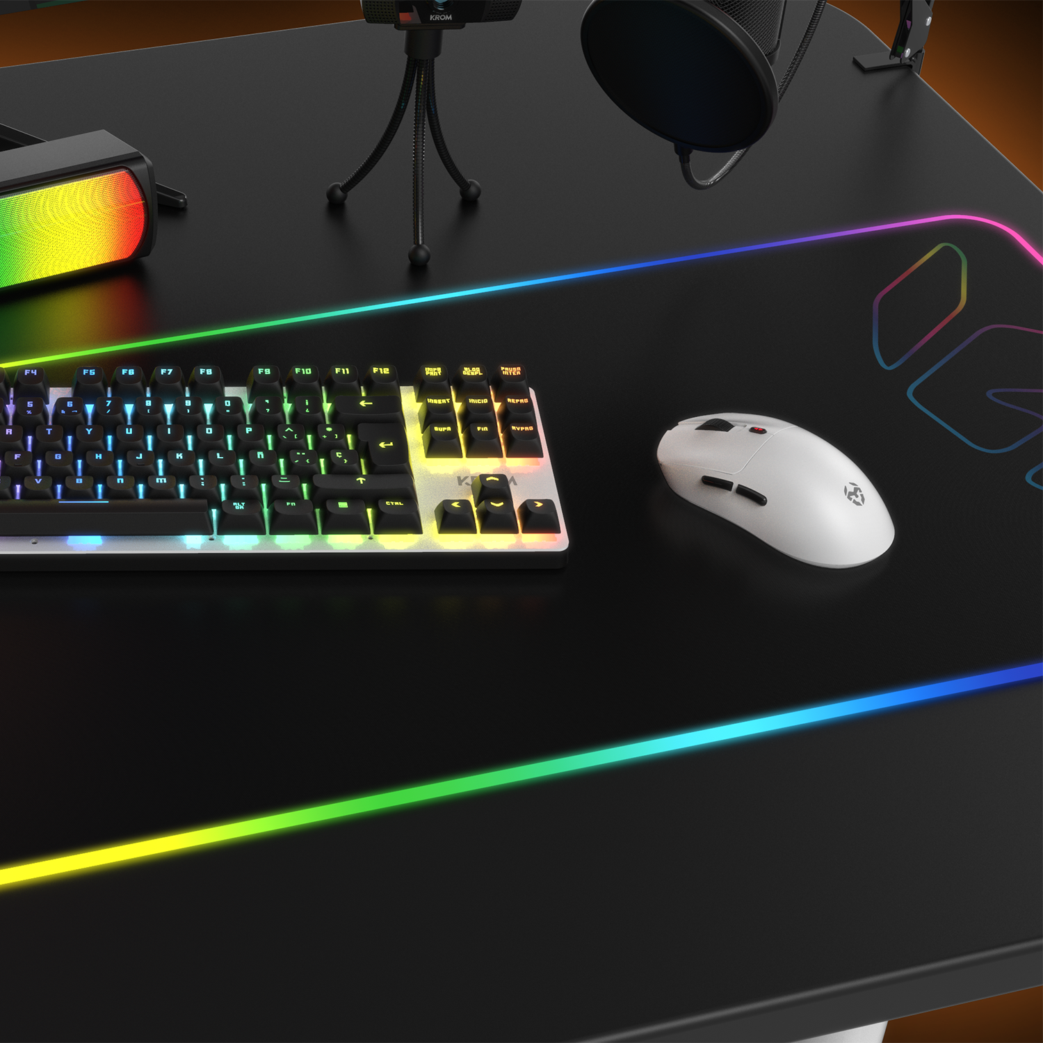 Escritorio con teclado, ratón, micrófono y altavoz. Iluminación RGB alrededor del escritorio y teclado.