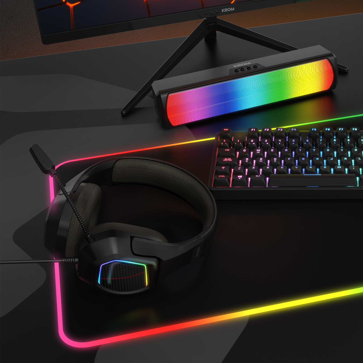 Configuración de jugador con teclado, auriculares y altavoz. Superficie negra con luces de colores.