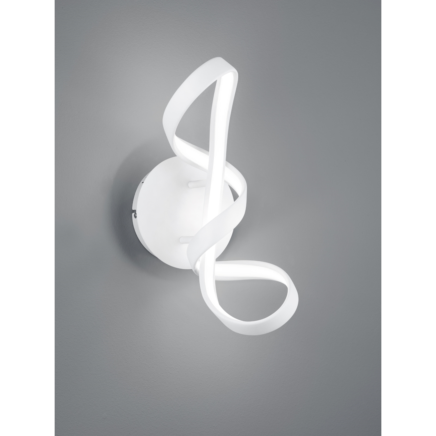 Una lampada da parete bianca e astratta con base circolare e design a nastro fluente.