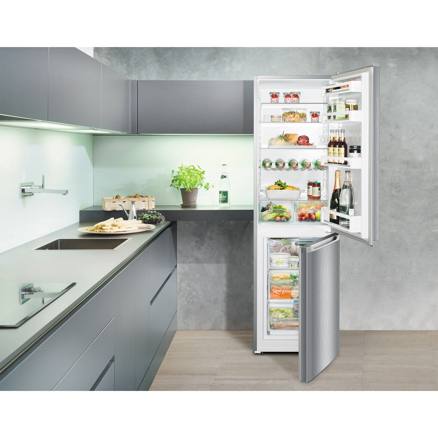 Una cucina moderna con un grande frigorifero aperto, pieno di cibo.