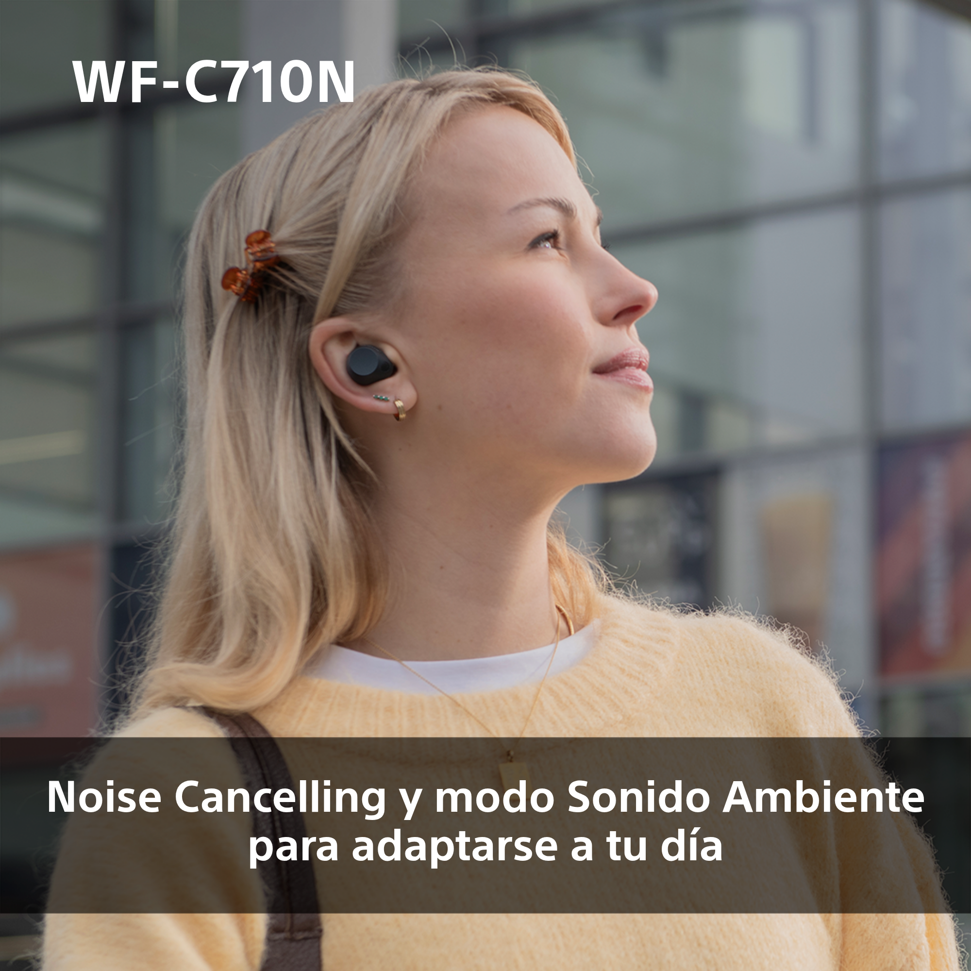 Mujer rubia con auriculares, mirando hacia arriba. El texto en la parte inferior dice: Cancelación de ruido y modo Sonido Ambiente.