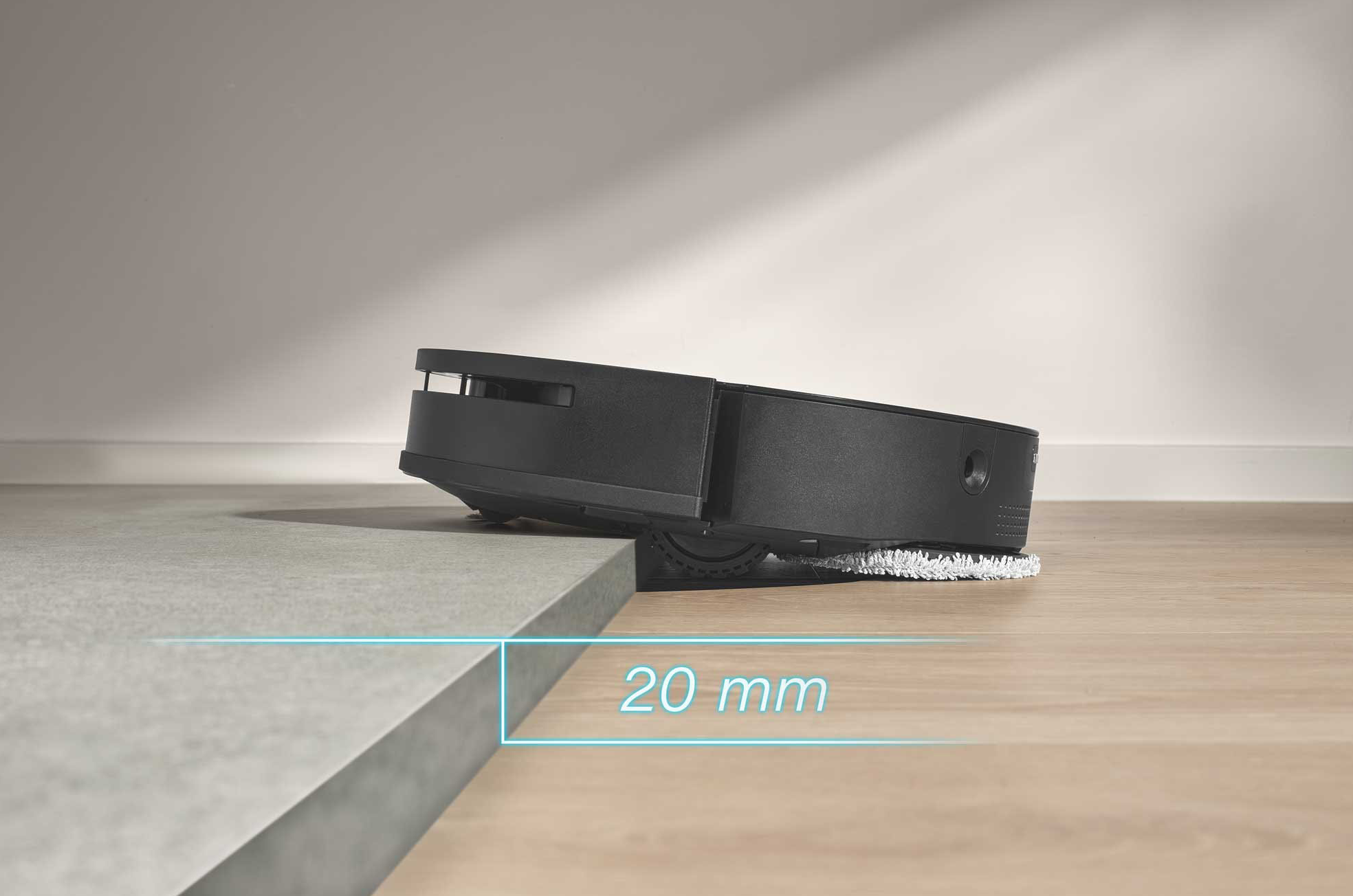 Robot porszívó, részben egy platformon, 20 mm-es hely látható.