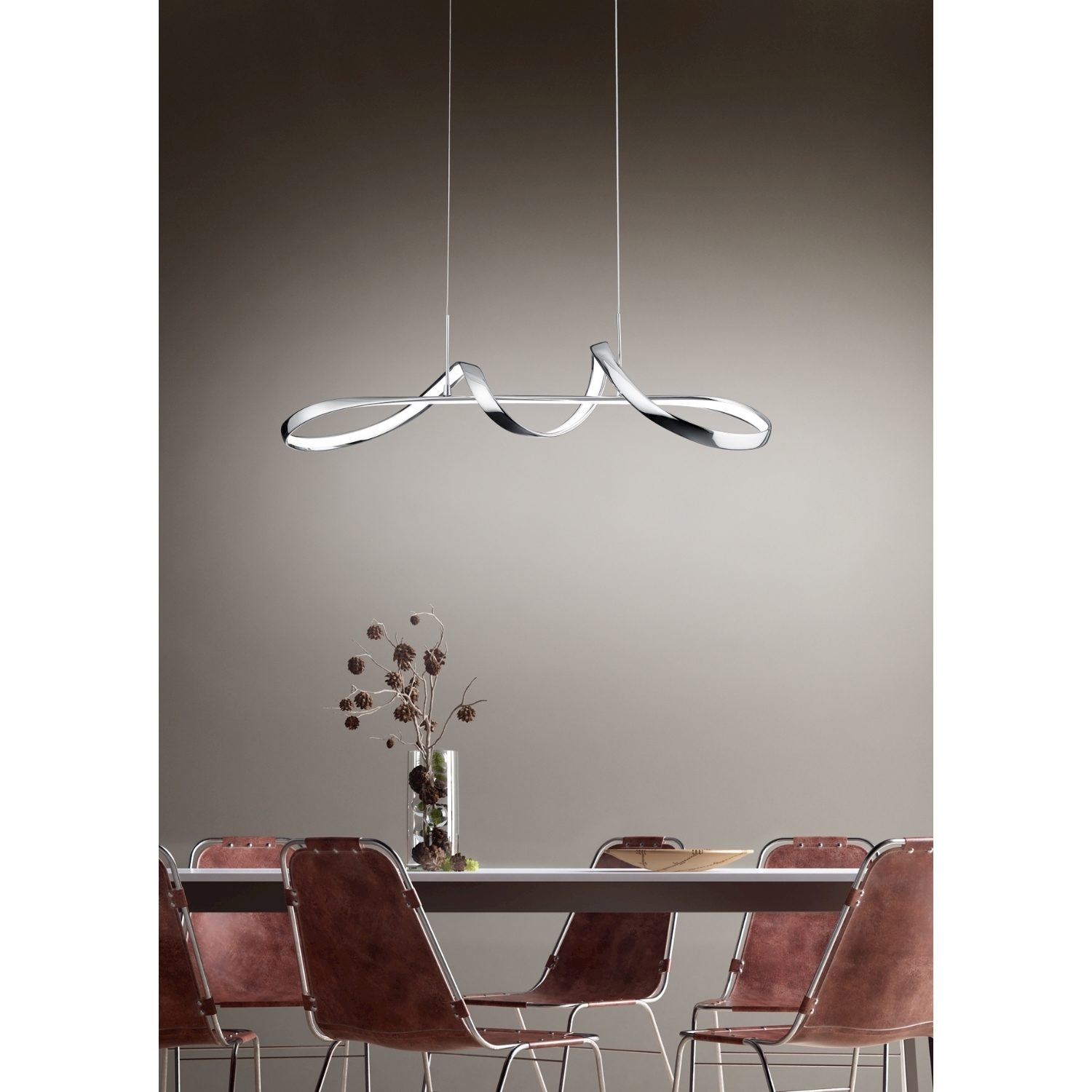 Un lampadario moderno, argentato e curvo appeso al soffitto sopra un tavolo.