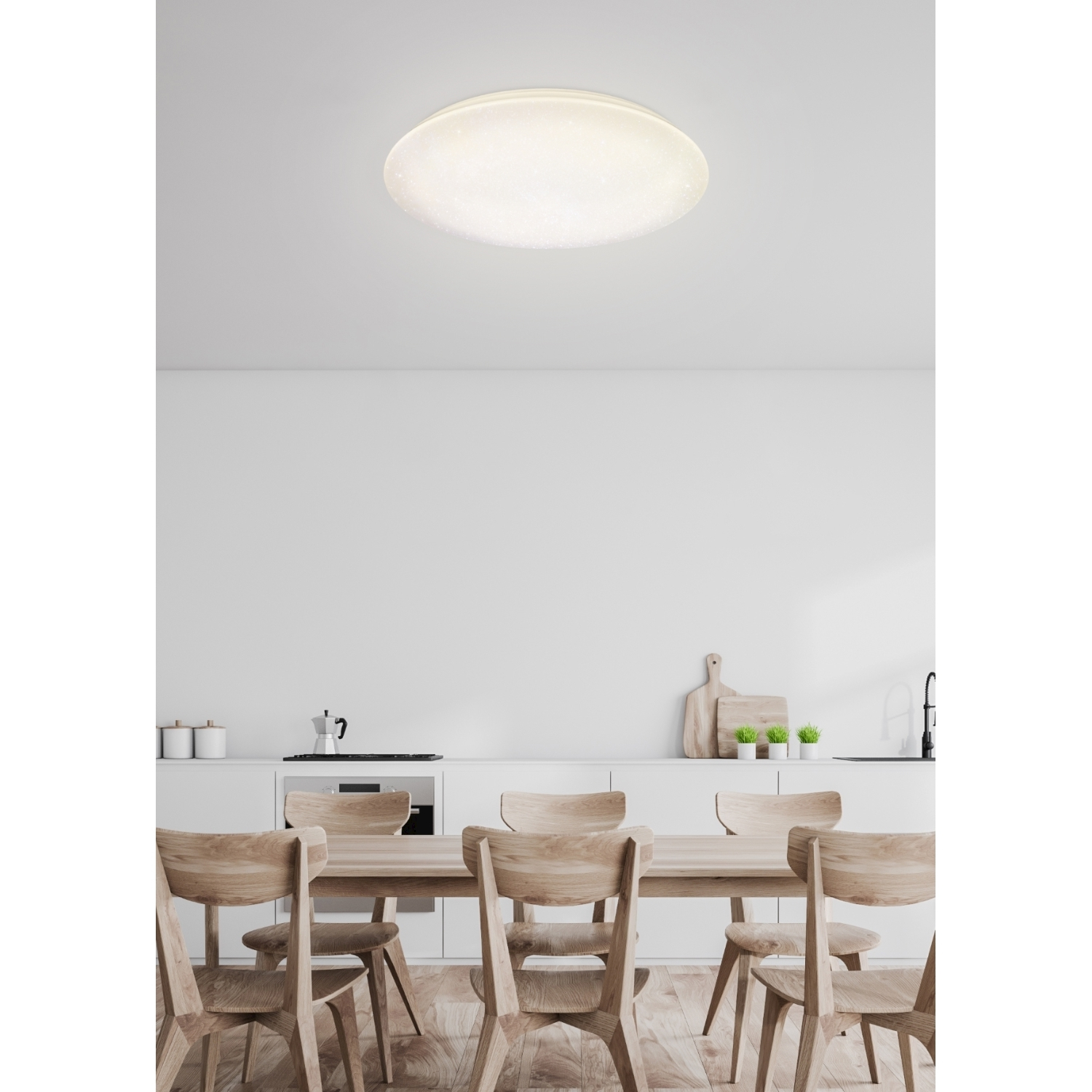 Un apparecchio di illuminazione a soffitto bianco sopra un tavolo da pranzo e sedie.
