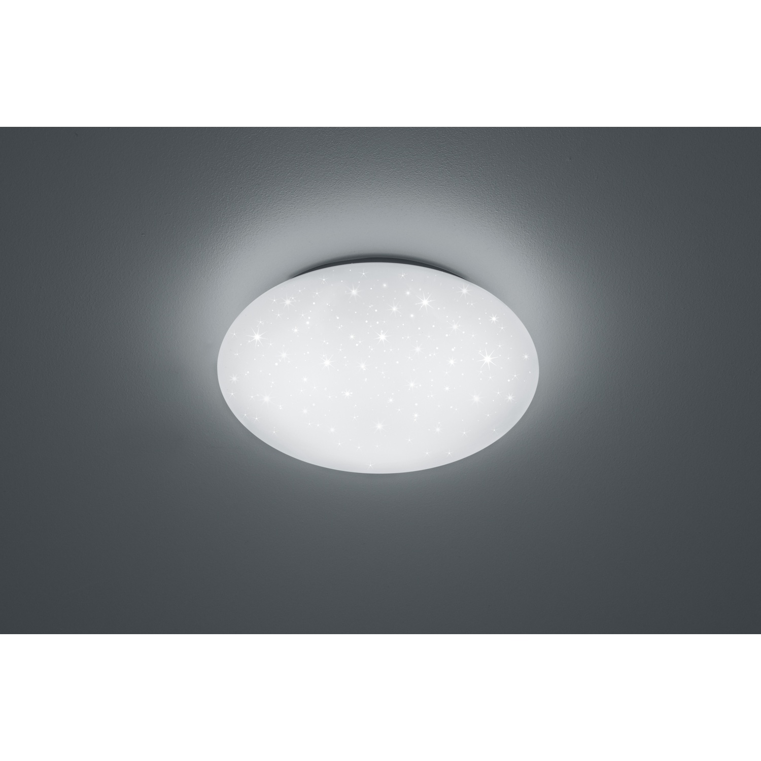 Lampada da soffitto rotonda con motivo a stelle, che emette una luce bianca, su soffitto grigio.