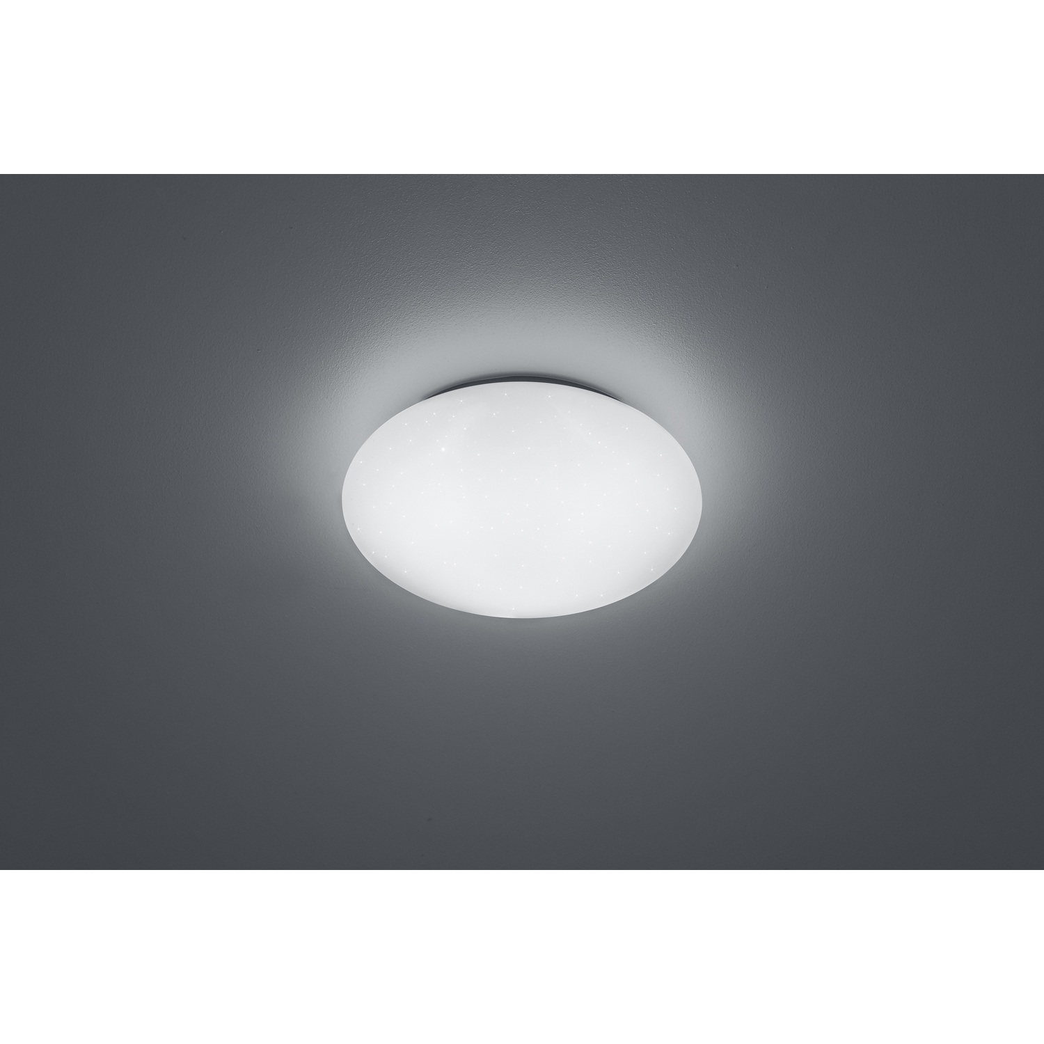 Una plafoniera bianca con un design circolare e piccoli dettagli a forma di stella su un soffitto grigio.