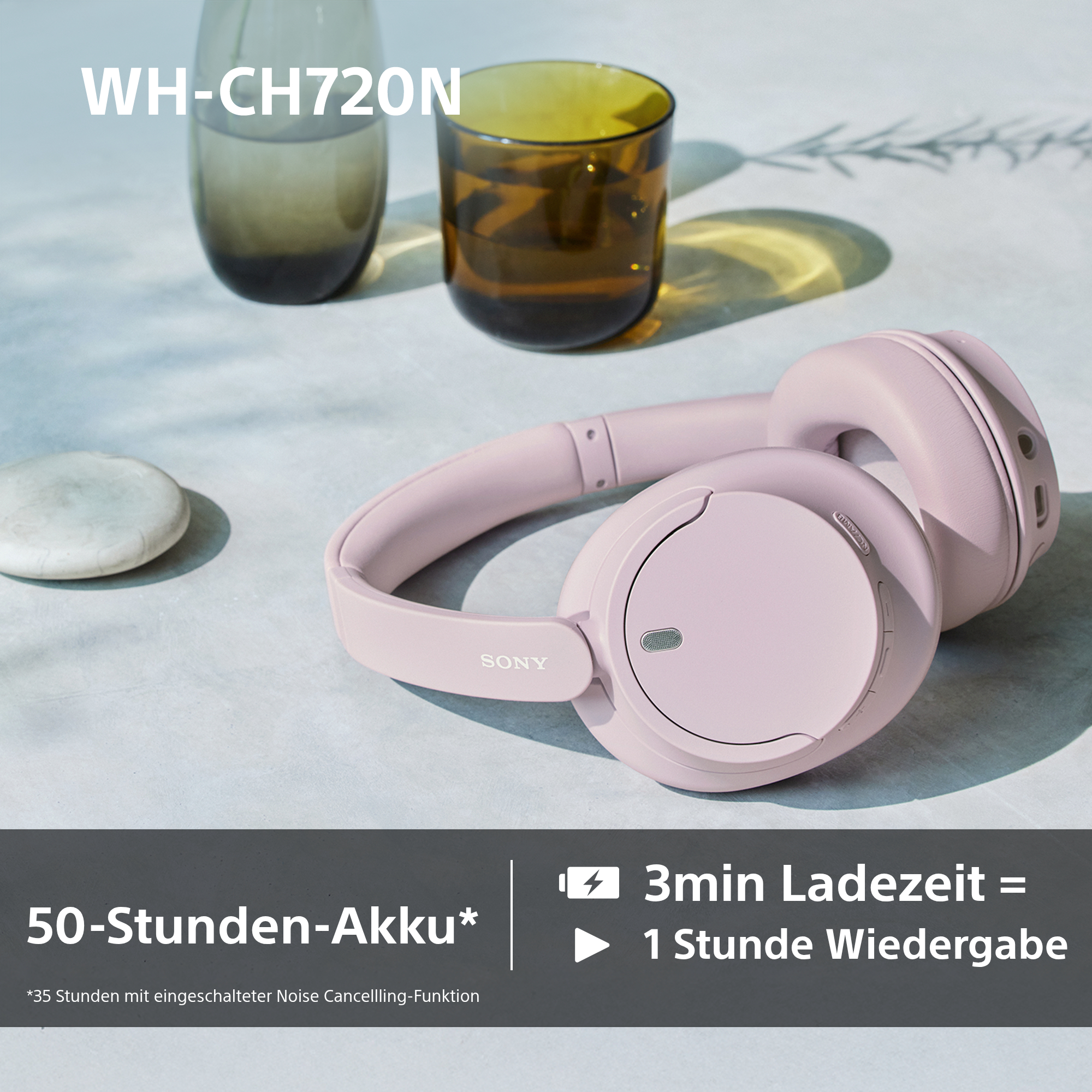Ein Paar rosa Kopfhörer auf einer hellen Oberfläche, mit Text, der besagt, dass sie eine 50-Stunden-Batterie haben.