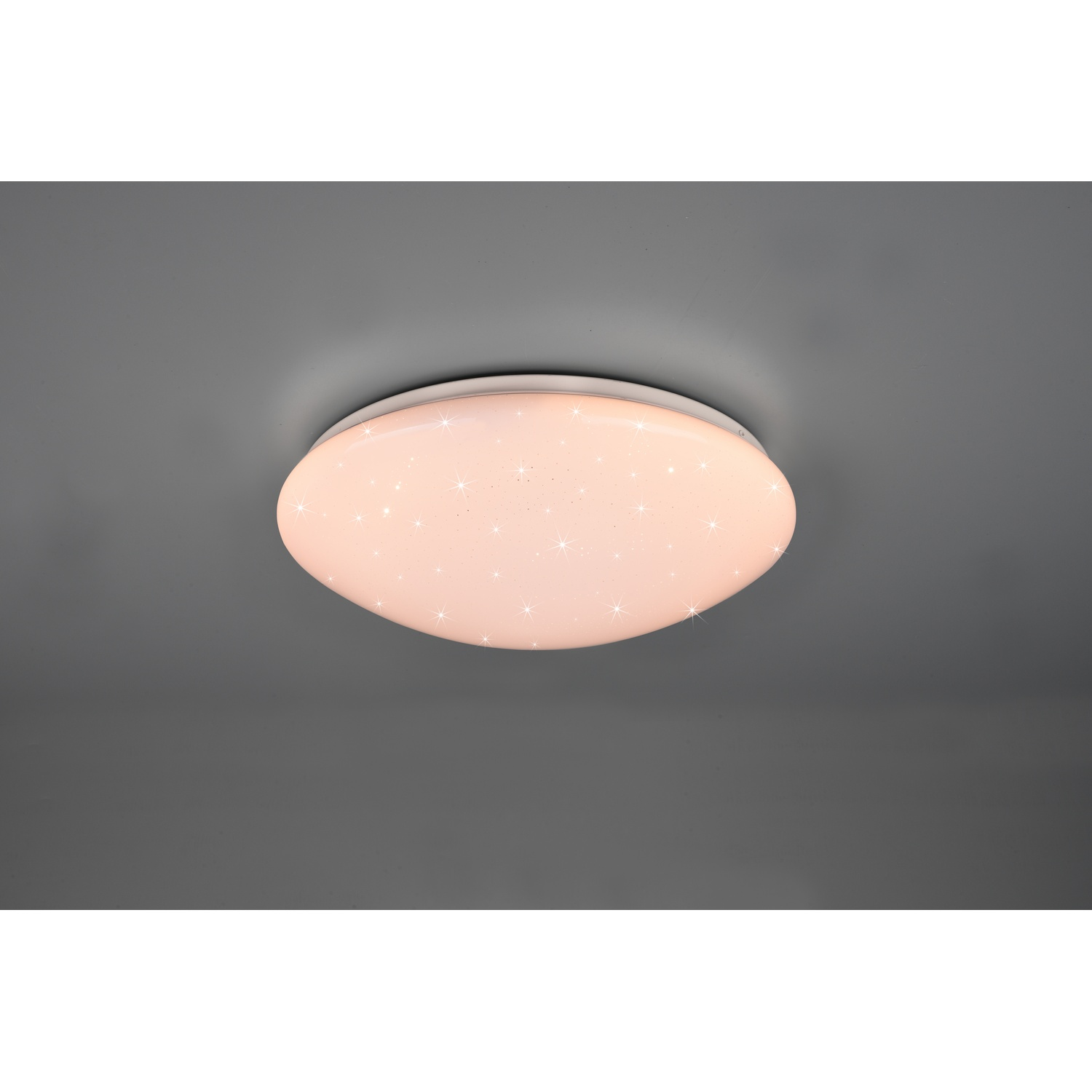 Plafoniera ovale con una luce soffusa e rosata e piccole luci a forma di stella su un soffitto grigio.