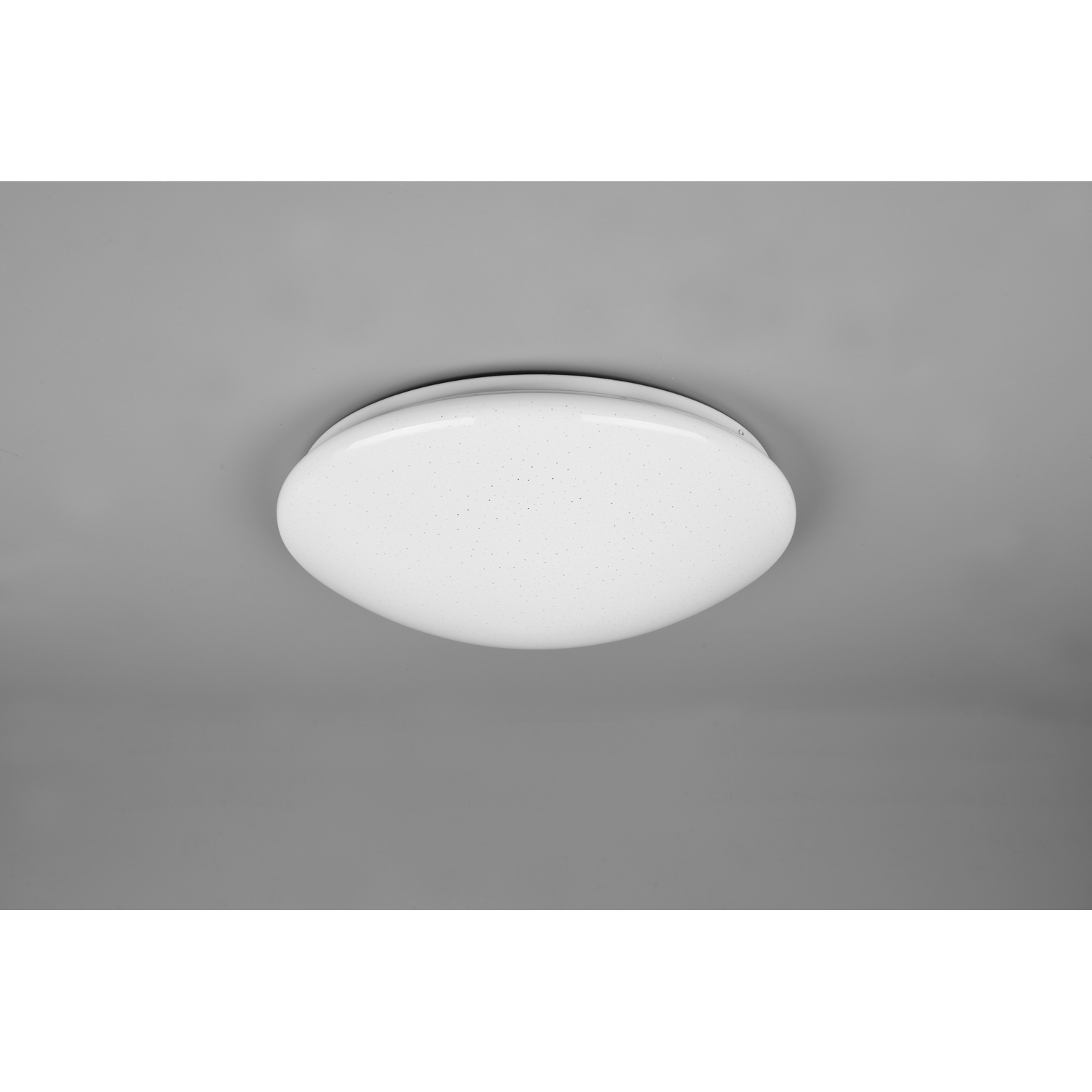 Lampada da soffitto bianca, ovale, con motivo a pois, contro un soffitto grigio.