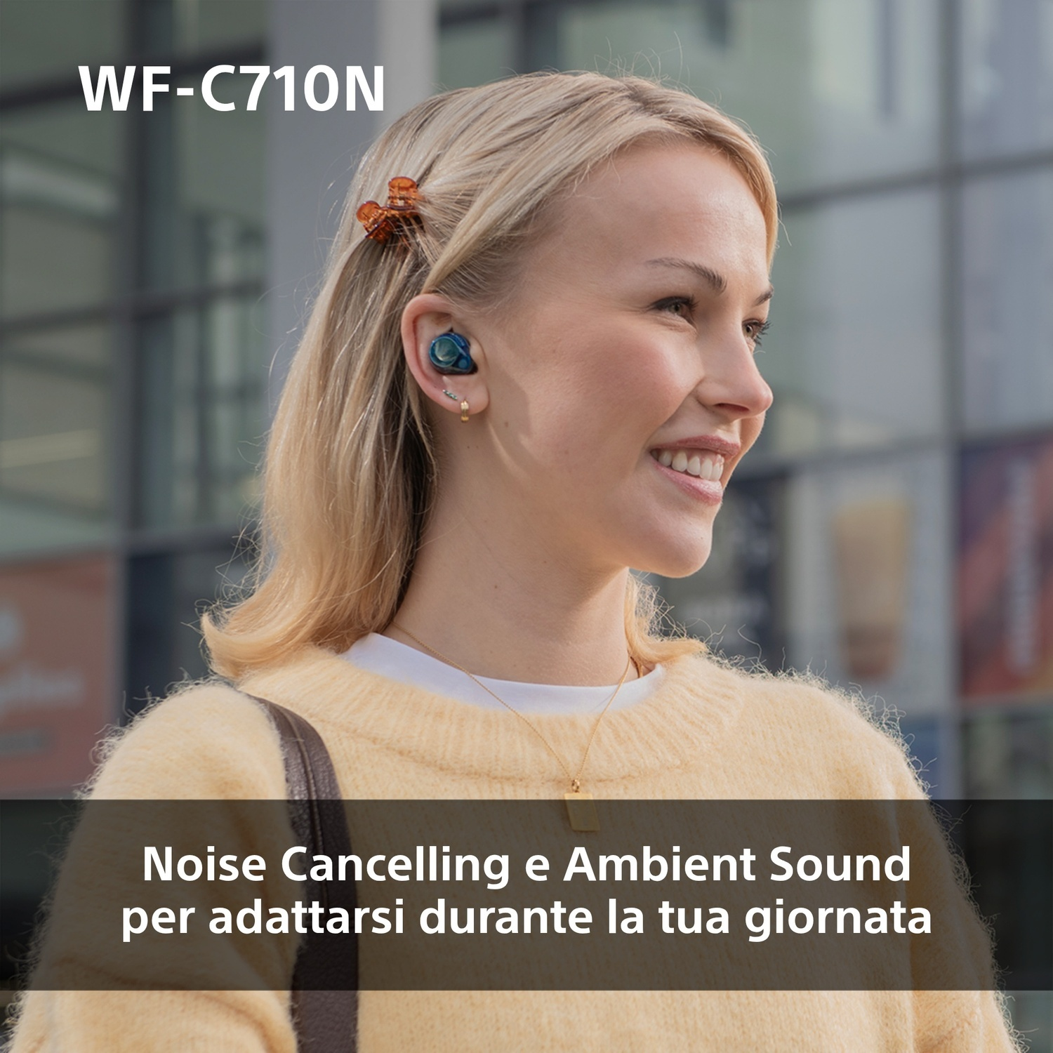 Donna bionda con auricolari nelle orecchie, sorridente. Testo: Cancellazione del rumore e suono ambientale per la tua giornata.