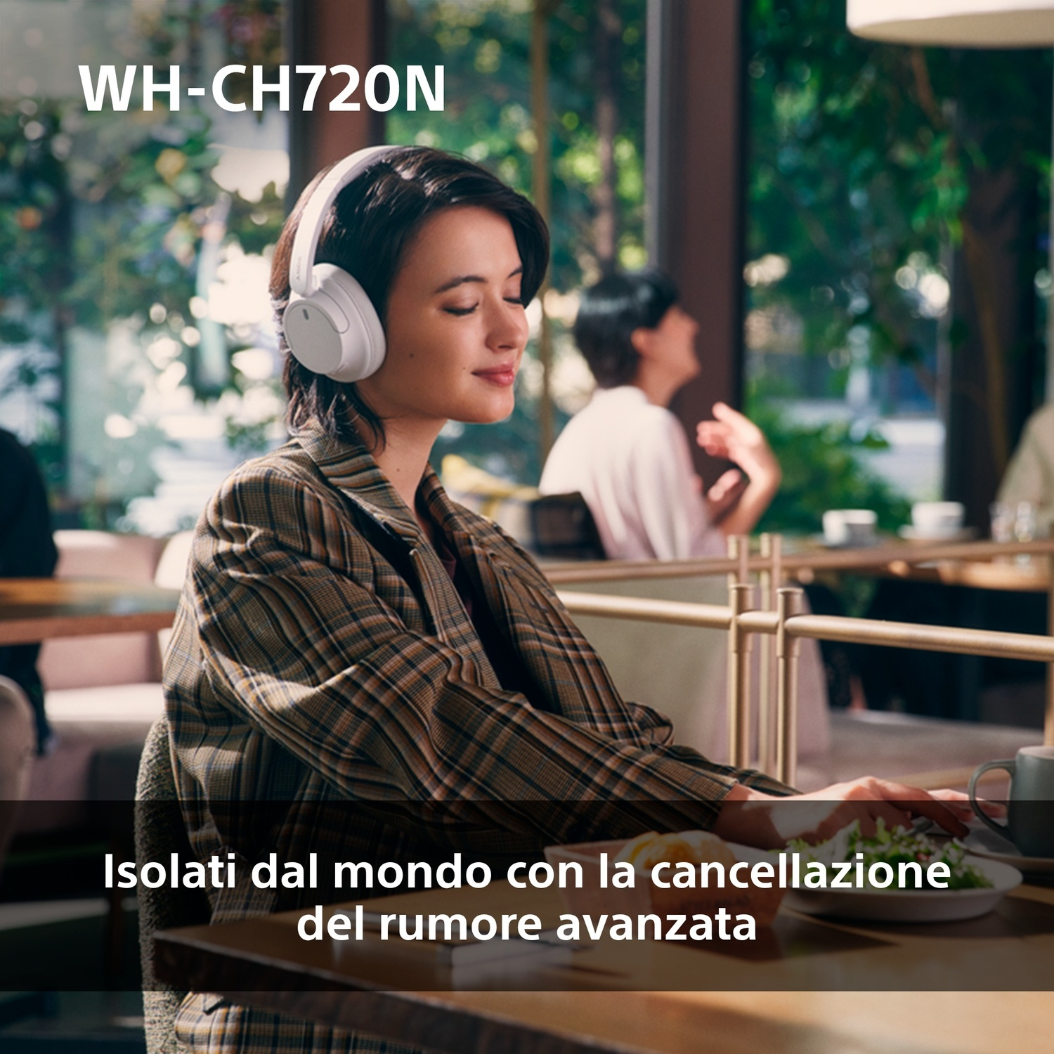 Una donna con cuffie bianche in un bar. Testo in italiano: Isolato dal mondo.