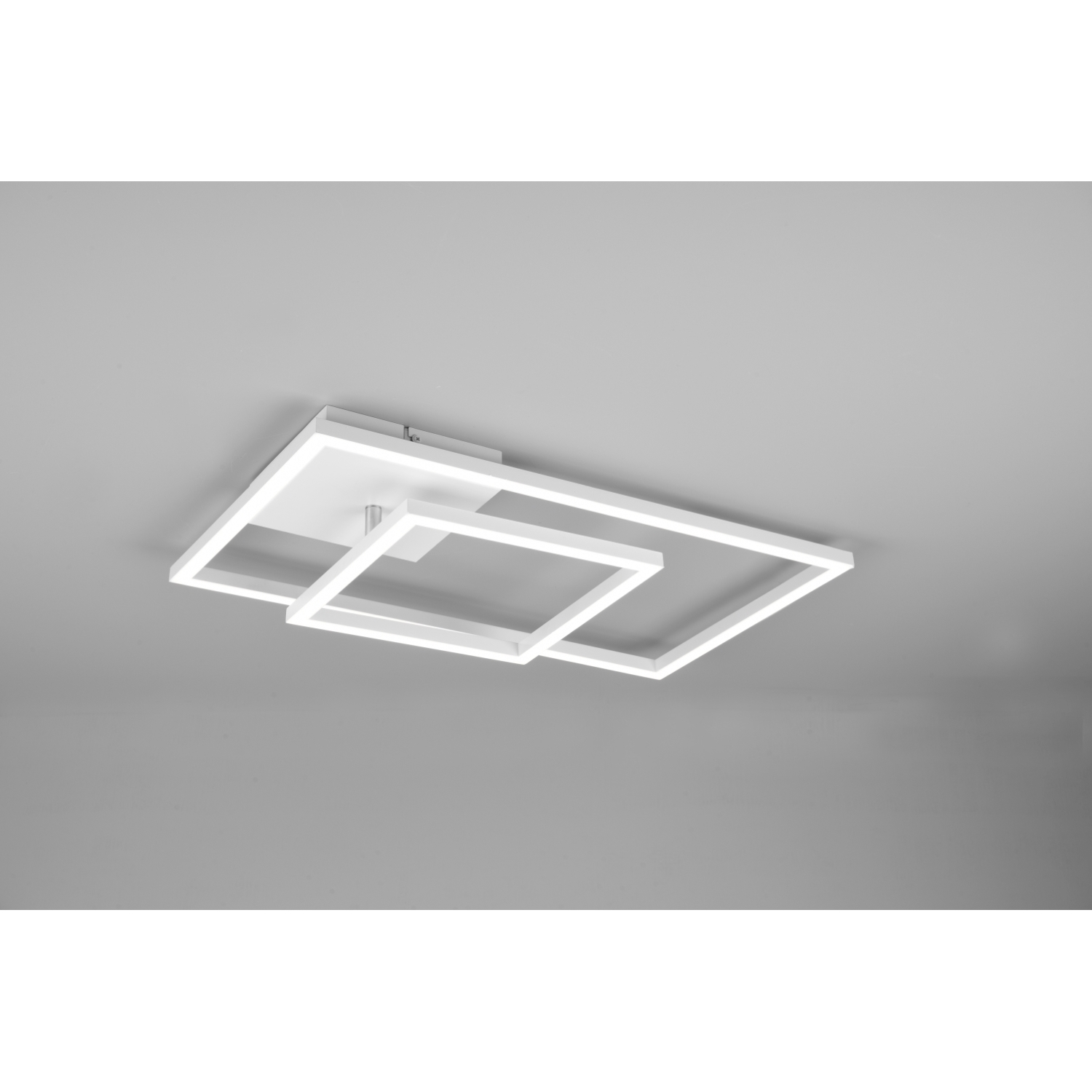 Lampada da soffitto geometrica bianca con tre telai quadrati collegati, su un soffitto grigio.