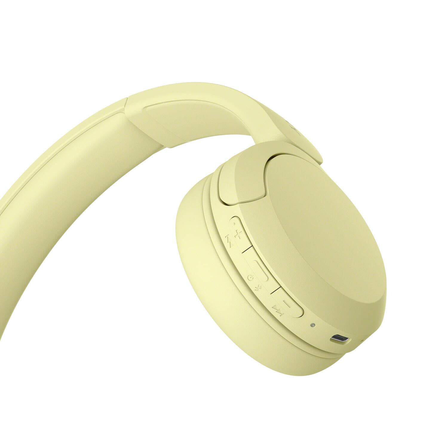 Gros plan d'un casque jaune. Le casque possède des boutons de volume et d'alimentation. Le design est élégant.