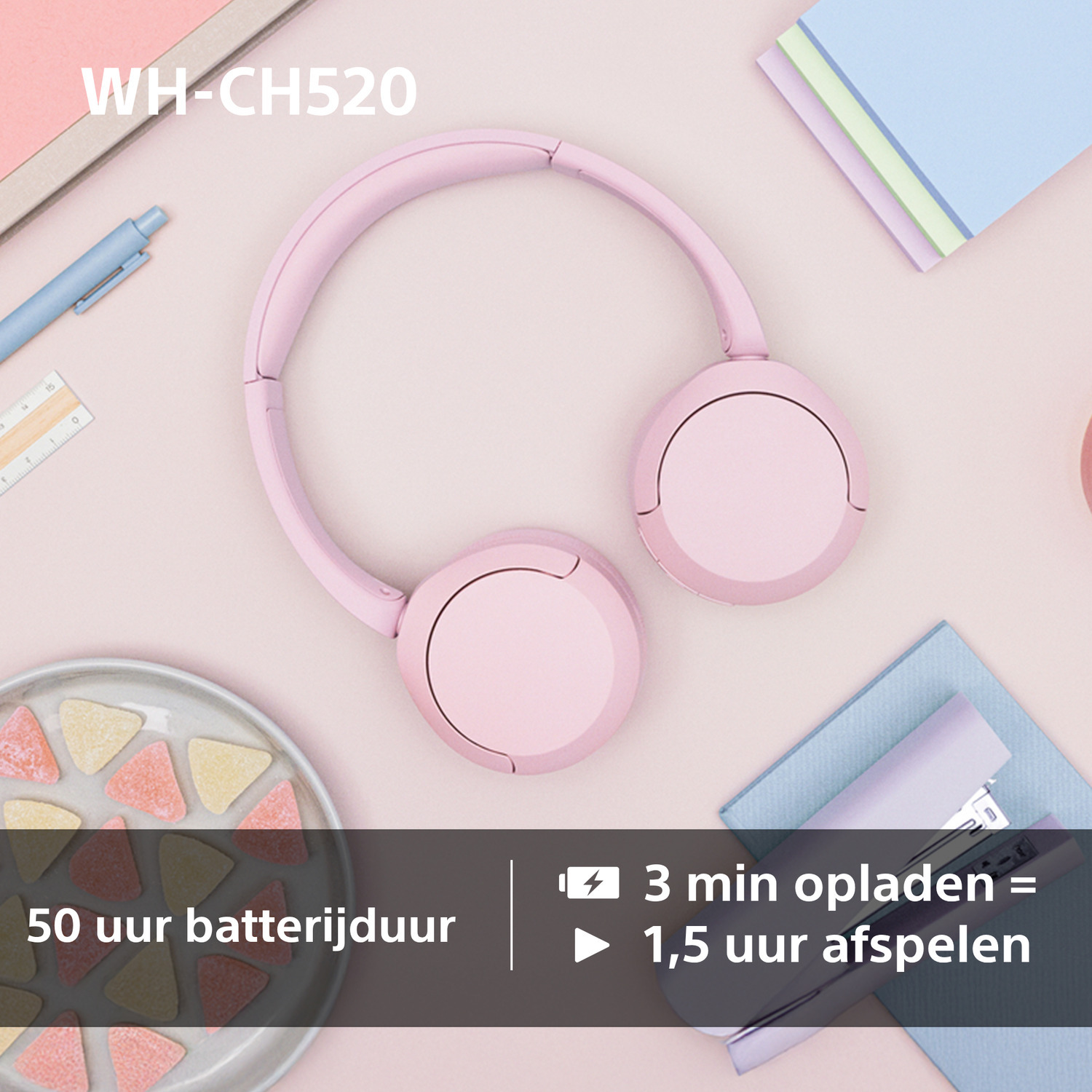 Roze koptelefoon op een roze oppervlak met accessoires. Tekst: WH-CH520.
