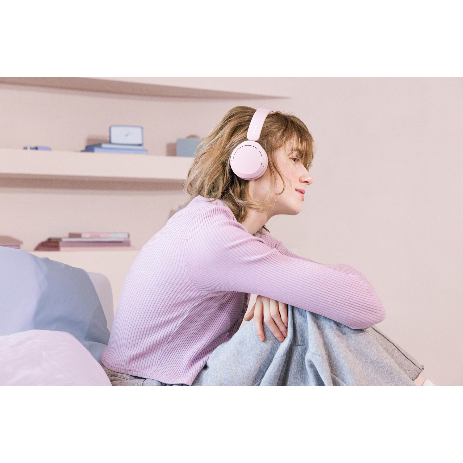 Une femme assise sur un lit portant un casque.