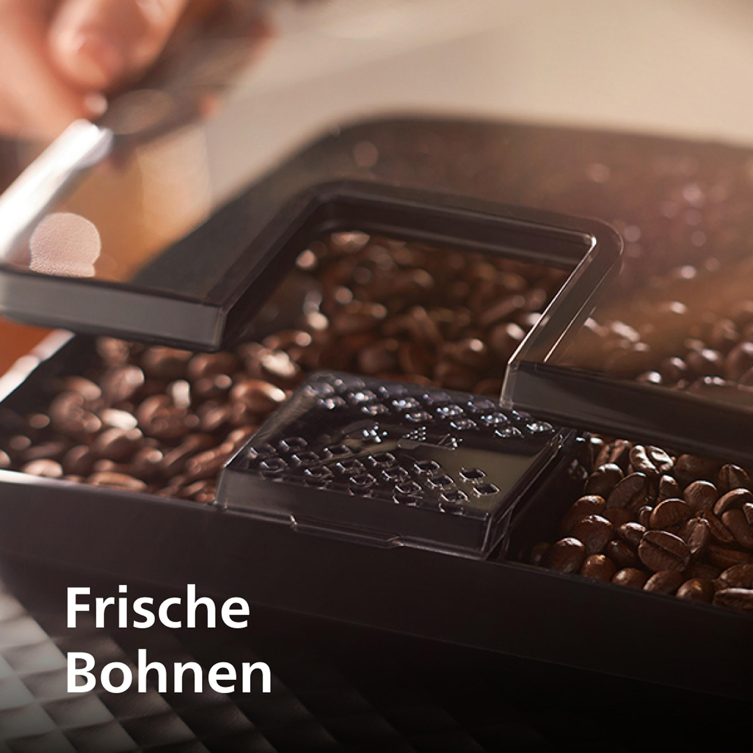 Kaffeebohnen werden in eine Maschine gegossen, Hand sichtbar.