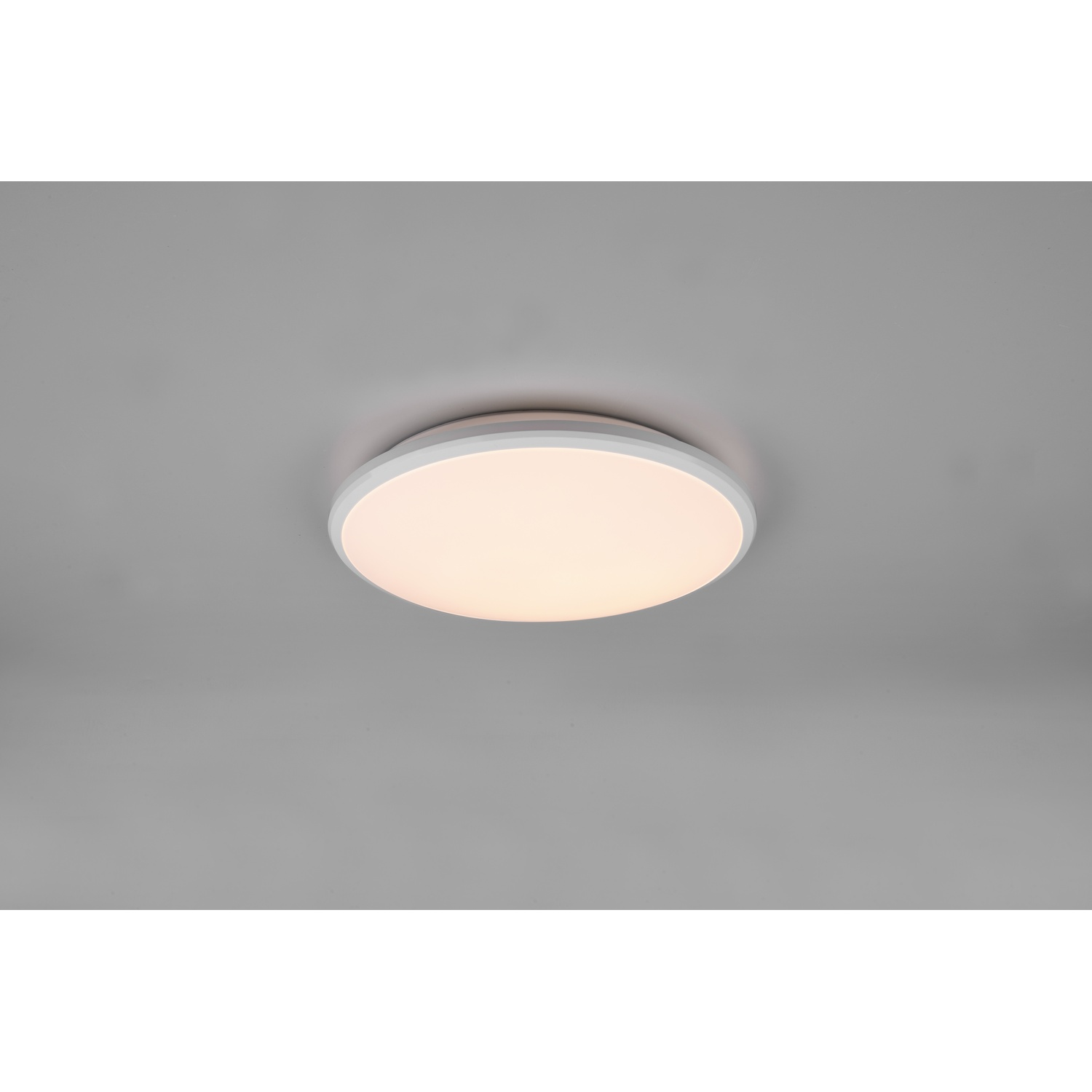 Lampada da soffitto rotonda con cornice bianca, che emette luce calda.