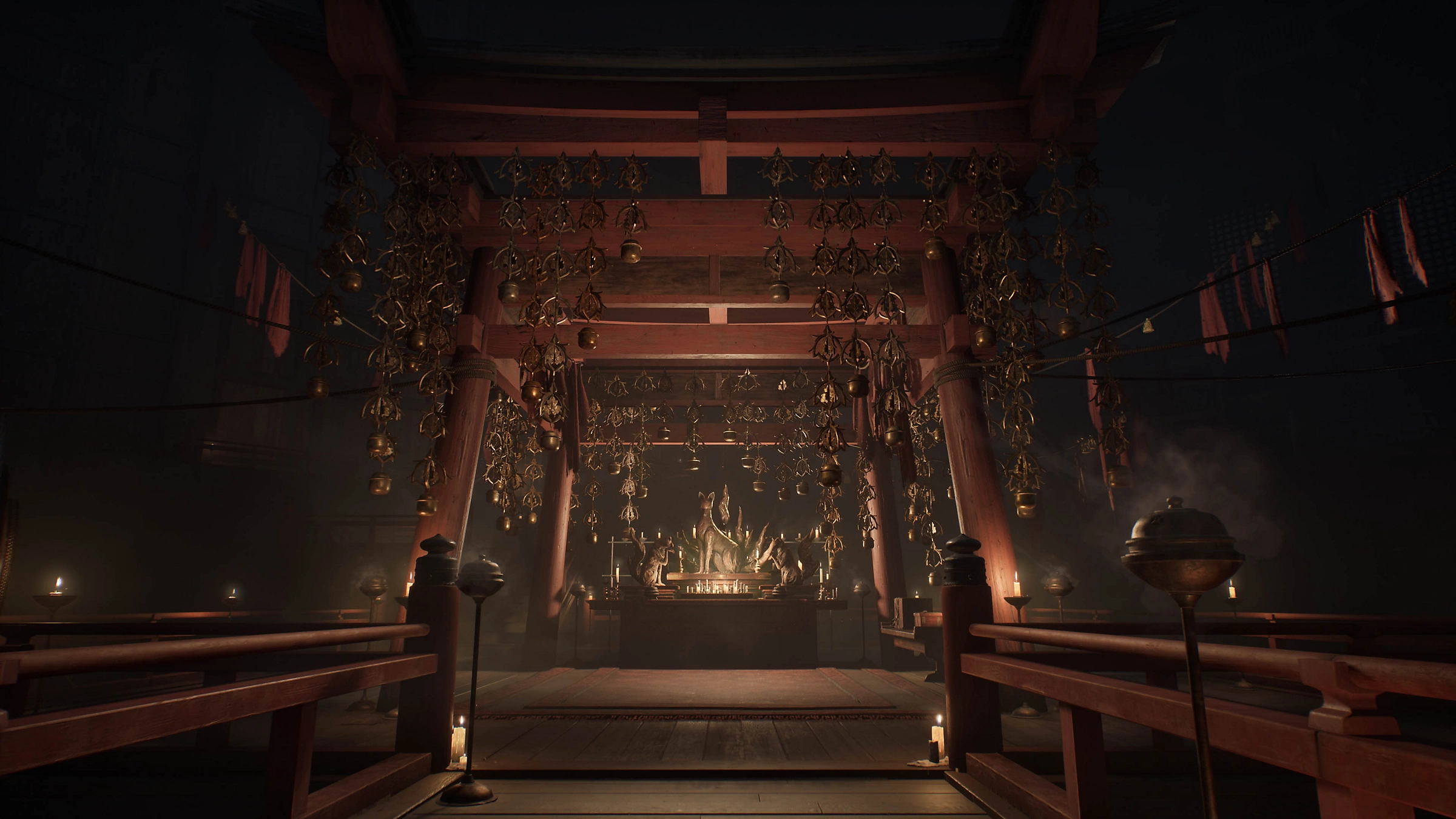 Dunkles Tempelinnere mit Holzkonstruktion, goldenen Glocken und Kerzen. Eine Statue ist am Altar zu sehen.