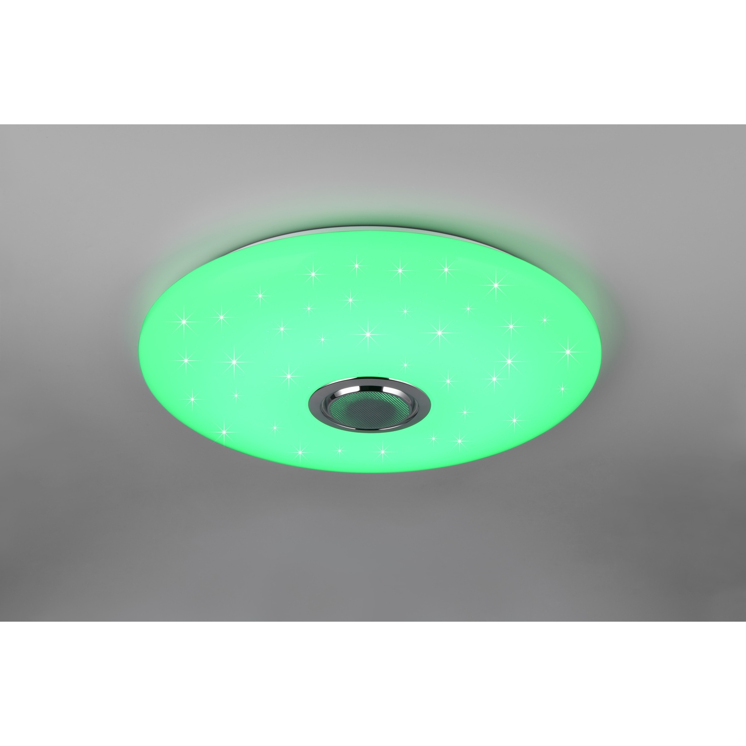 Una plafoniera rotonda emette luce verde con motivi a stella. Un altoparlante è al centro.
