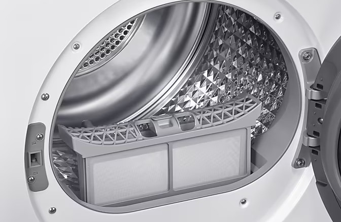Otwarty bęben białej pralki z filtrem i wzorzystą ścianą wewnętrzną.