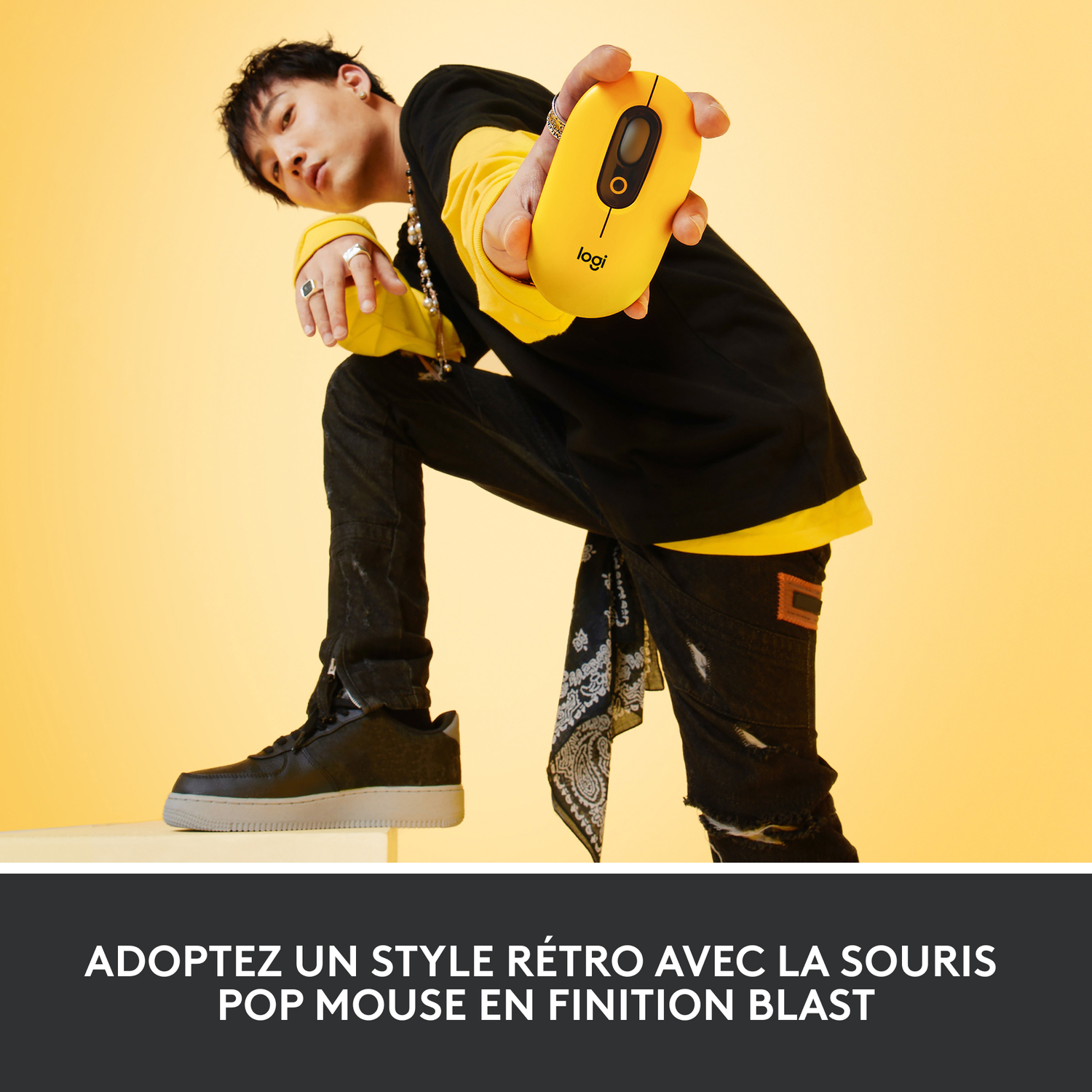 Une personne tenant une souris d'ordinateur jaune, avec un fond jaune.