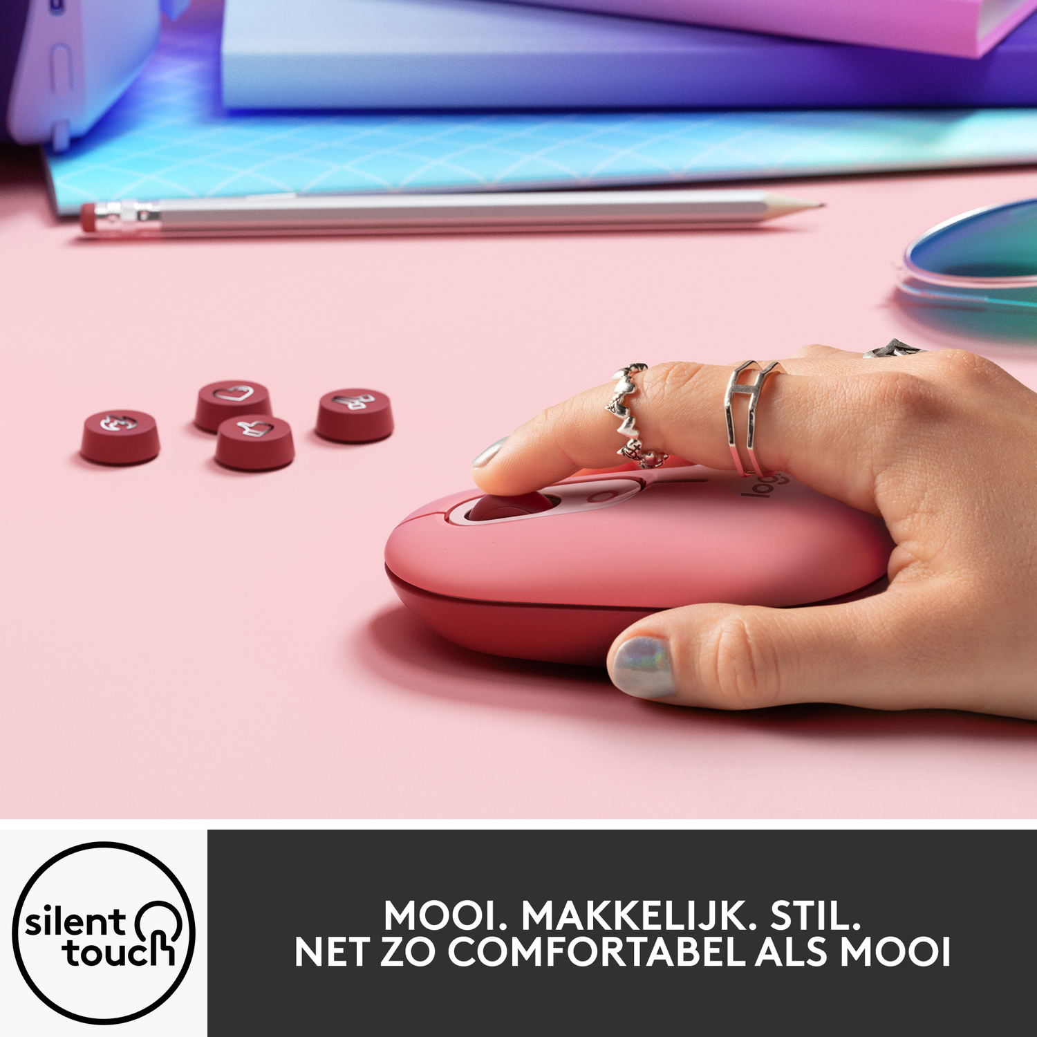 Hand van een persoon op een roze muis met rode keycaps. De muis staat op een roze bureau.