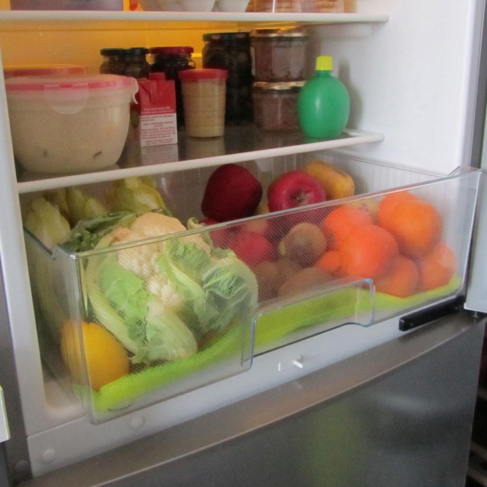 Un interior de refrigerador lleno de alimentos en recipientes y cajones, bien organizado.
