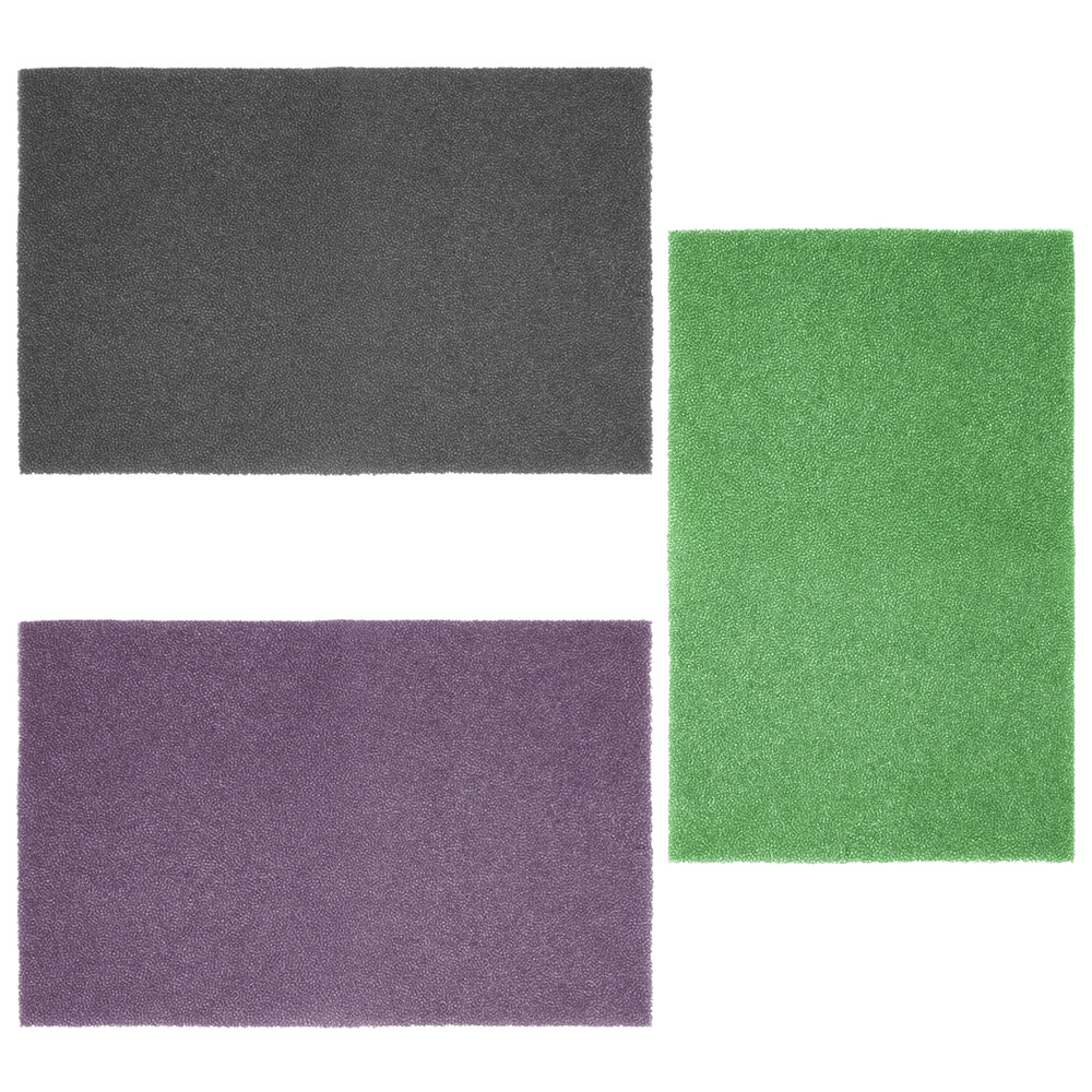 Tres alfombras rectangulares: gris oscuro, morado y verde. Todas tienen una superficie texturizada.