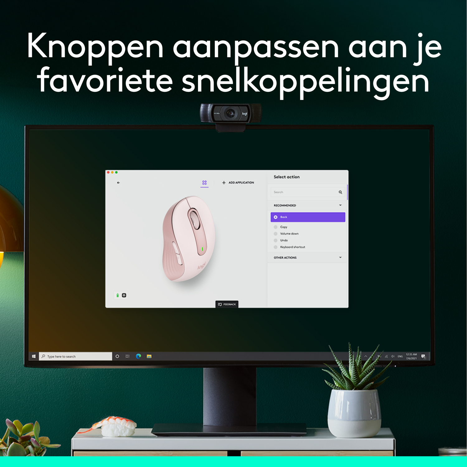 Computer screen with a pink mouse on the screen, with a webcam and a plant.