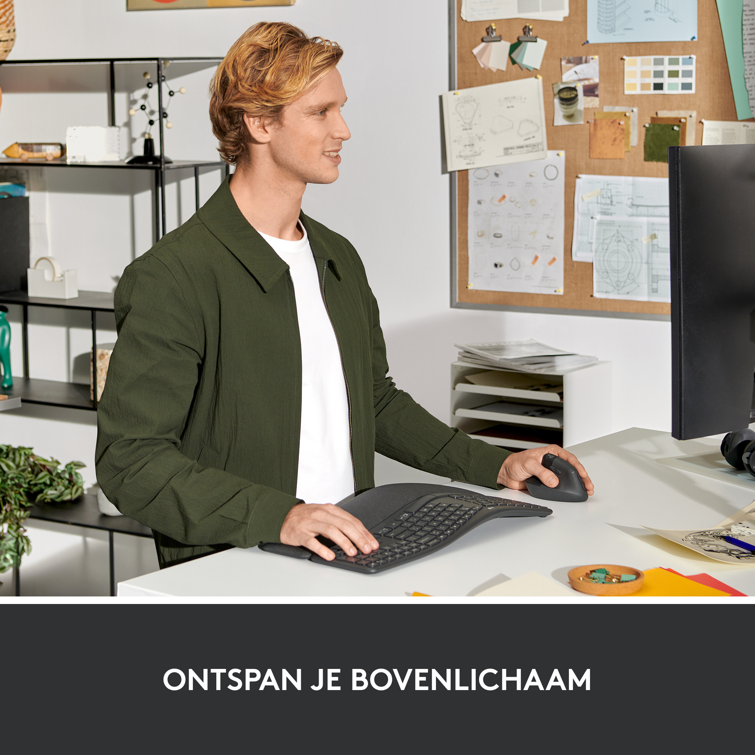 Man using curved keyboard and mouse at a white desk.