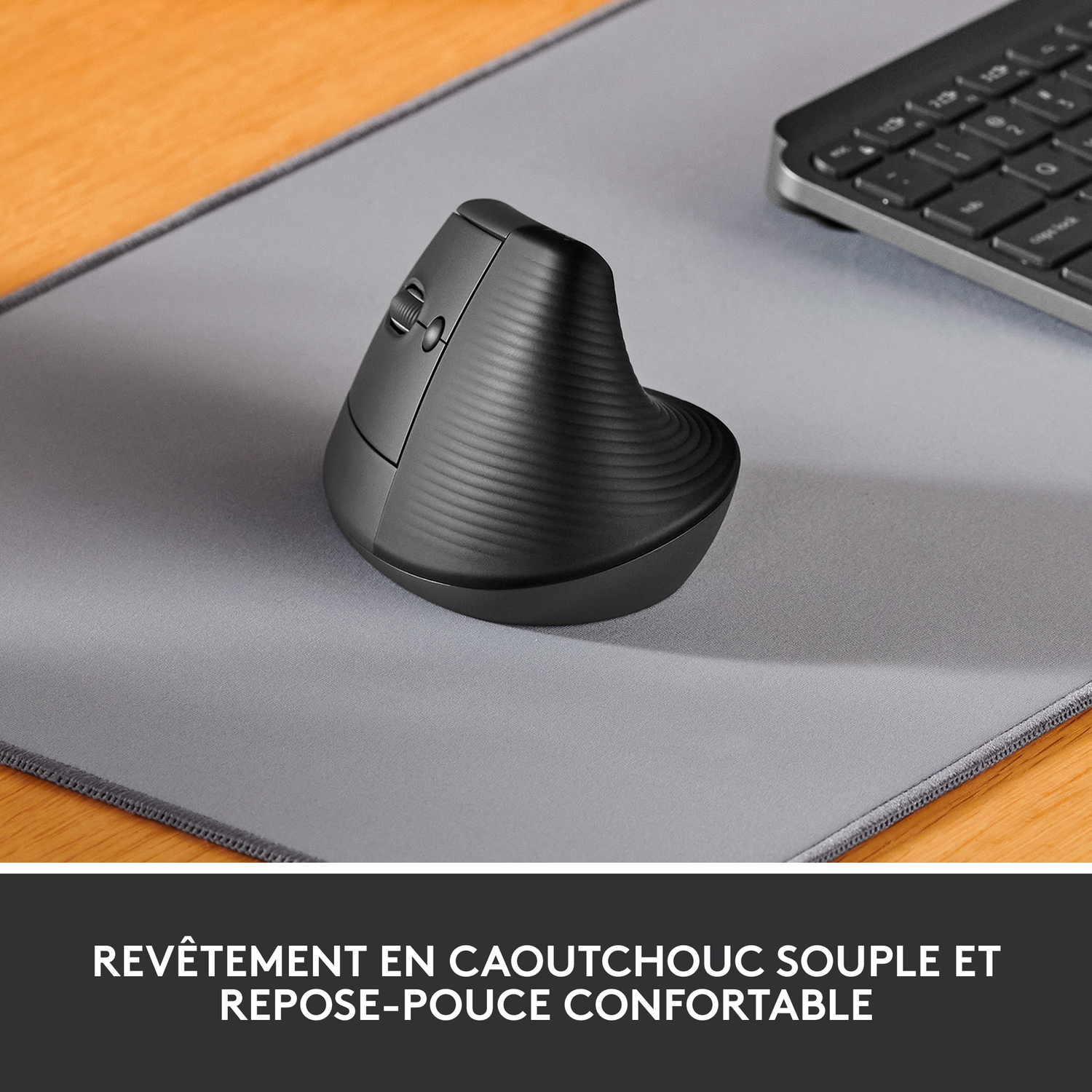 Une souris ergonomique noire repose sur un tapis de souris gris, avec un clavier en arrière-plan, avec du texte français en dessous.