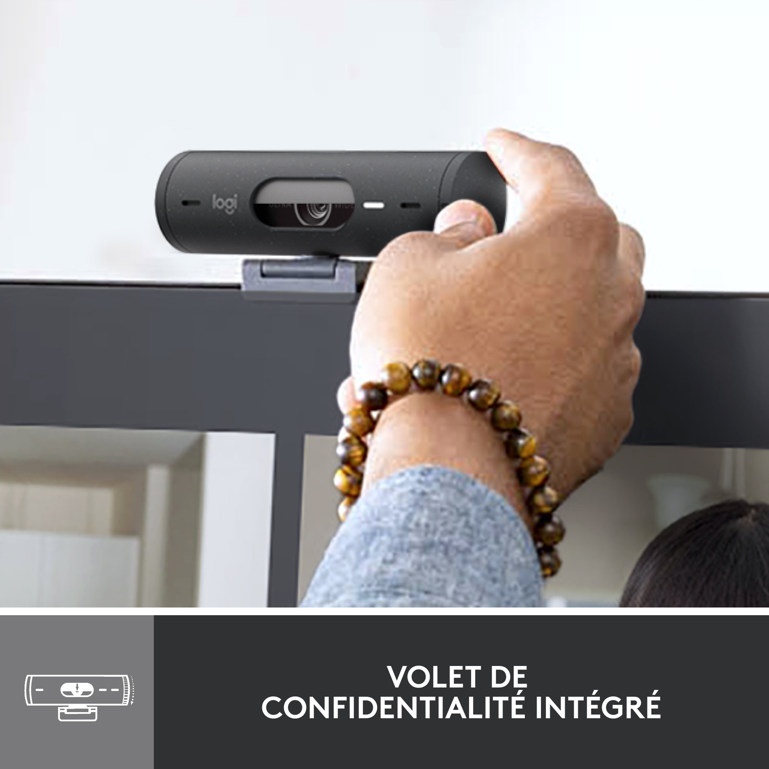 Main d'une personne ajustant une webcam noire avec le texte "VOLET DE CONFIDENTIALITÉ INTÉGRÉ".