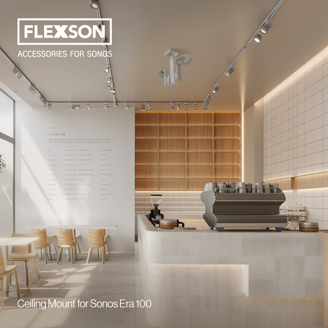 Ein modernes Café-Interieur mit Deckenhalterung für Sonos Era 100-Lautsprecher und einer weißen Wand mit Text.