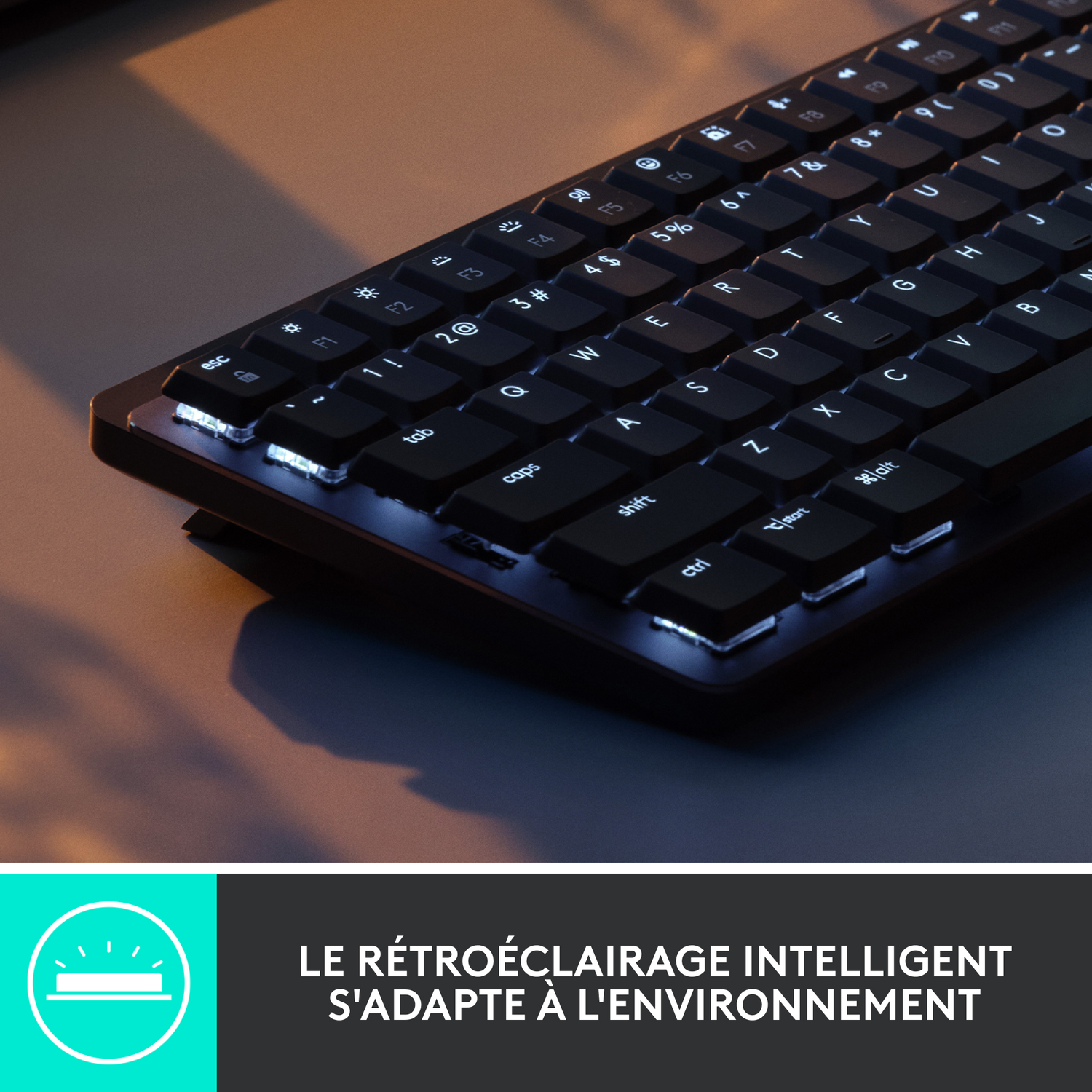 Clavier noir avec touches rétroéclairées. Le texte dit "LE RÉTROÉCLAIRAGE INTELLIGENT S'ADAPTE À L'ENVIRONNEMENT".