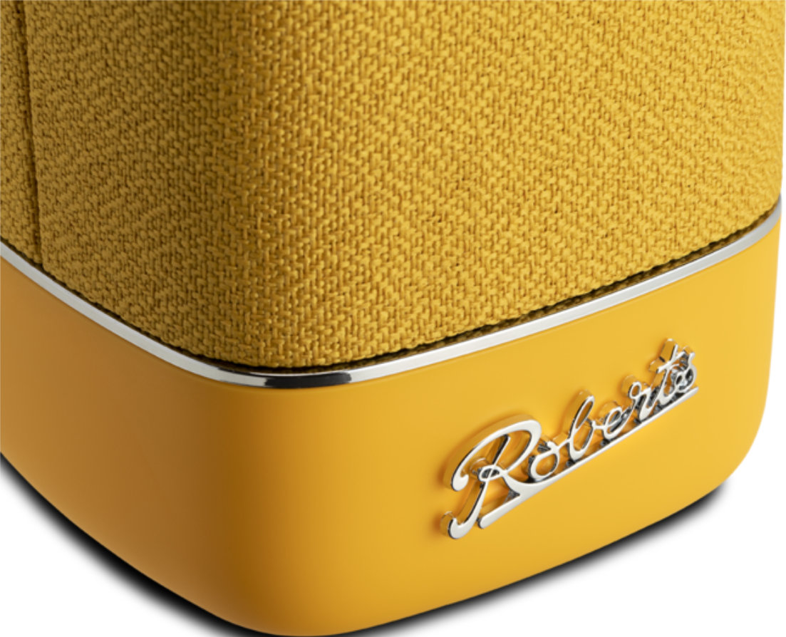 Gros plan sur la base d'un haut-parleur jaune avec garniture argentée et le logo Roberts.