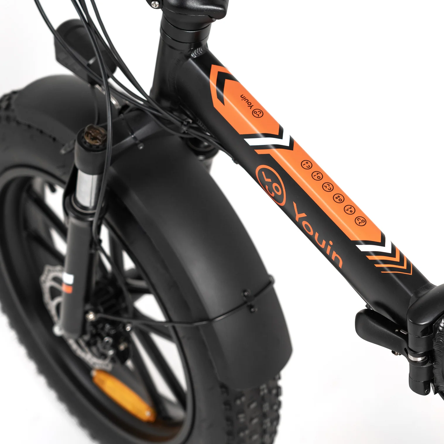 Primer plano de una bicicleta Youin negra y naranja. La rueda delantera, el cuadro y el manillar son visibles sobre un fondo blanco.