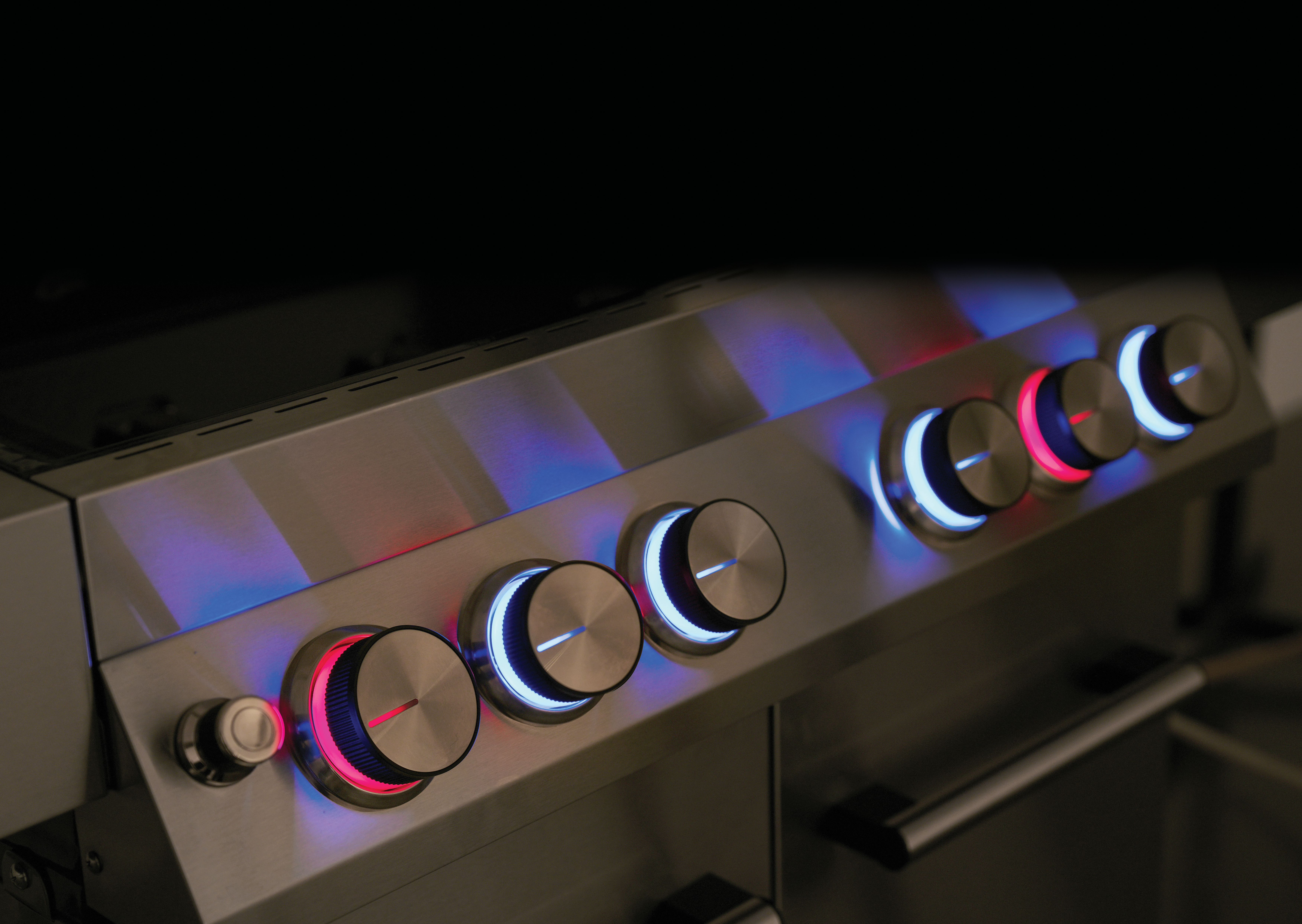 Nahaufnahme eines Edelstahlgrills mit beleuchteten Bedienknöpfen.