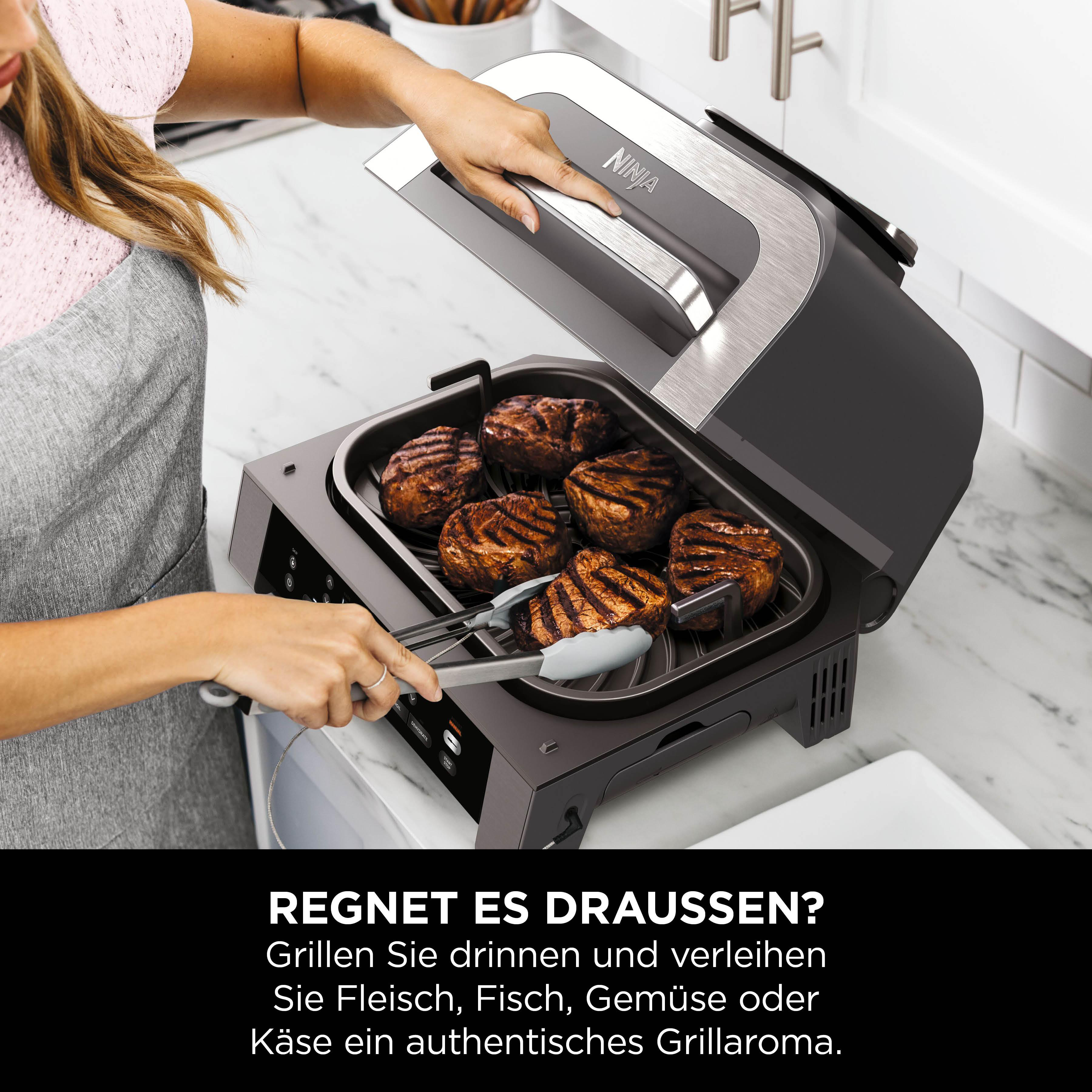 Frau grillt Steaks in einer Küche mit einem Ninja-Grill. Fleisch ist im Grill.