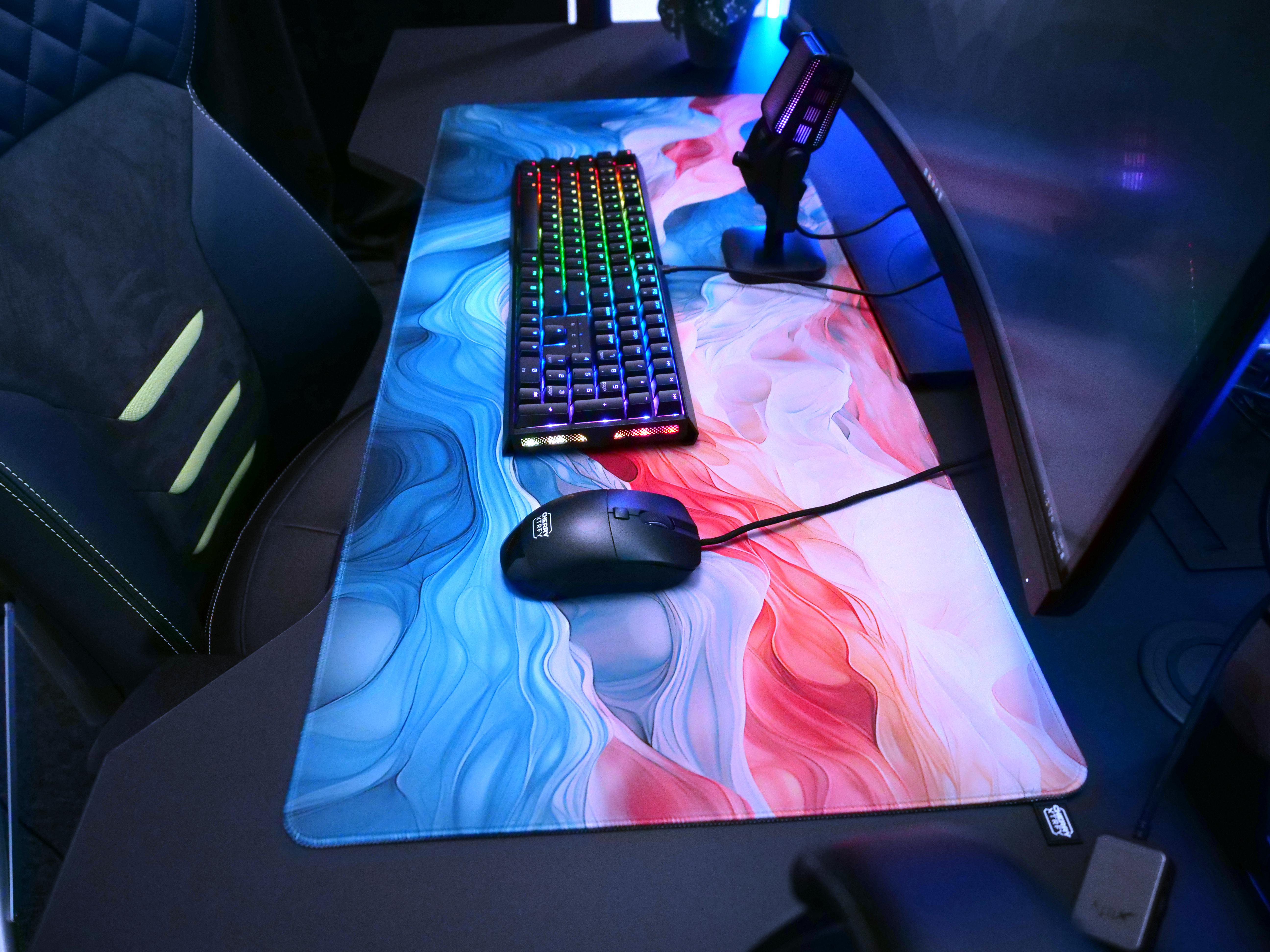 Gaming-Setup mit Tastatur, Maus und großem blau-roten Mauspad.