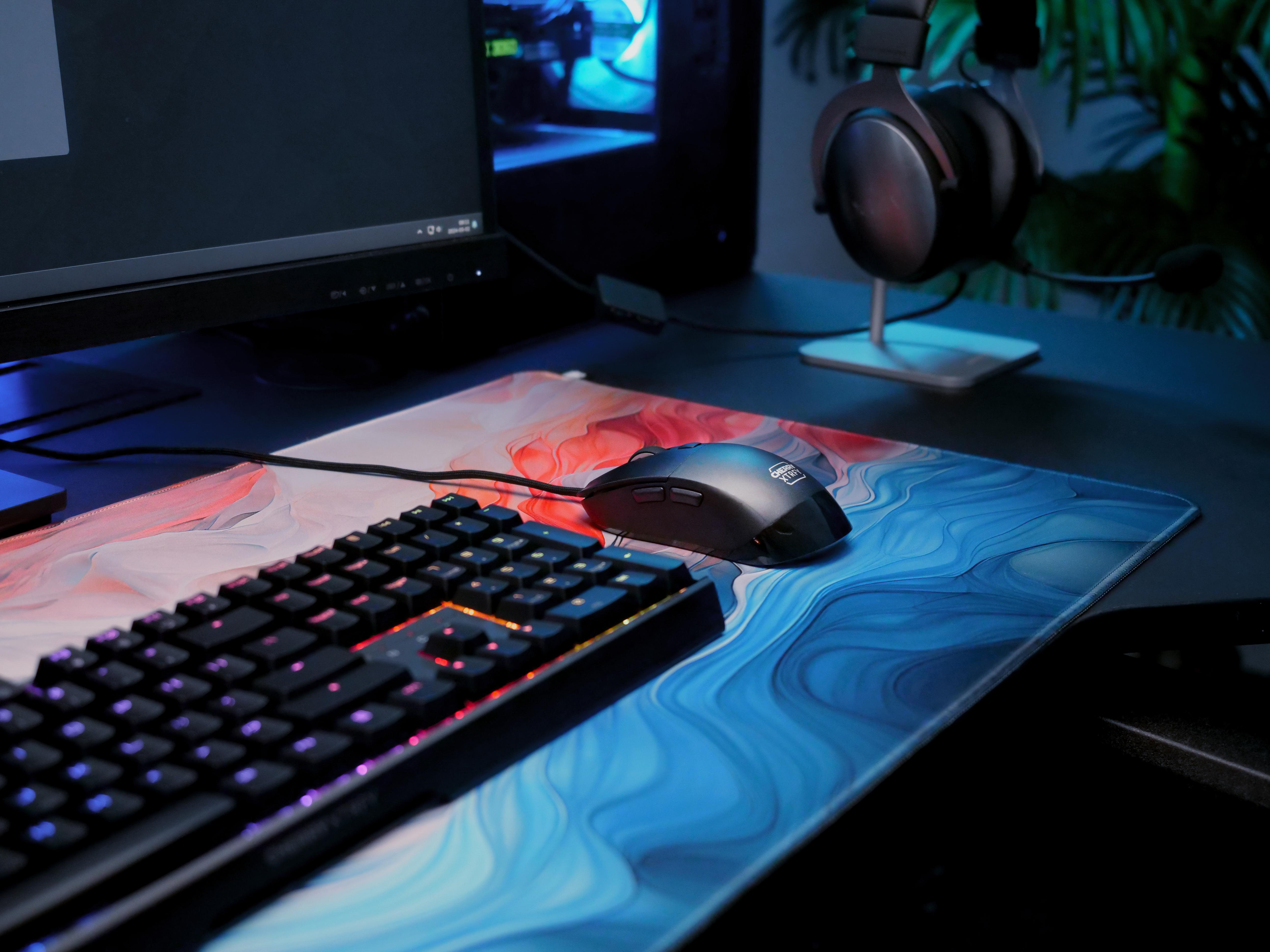 Gaming-Setup mit Tastatur, Maus und Kopfhörern auf einem Schreibtisch.