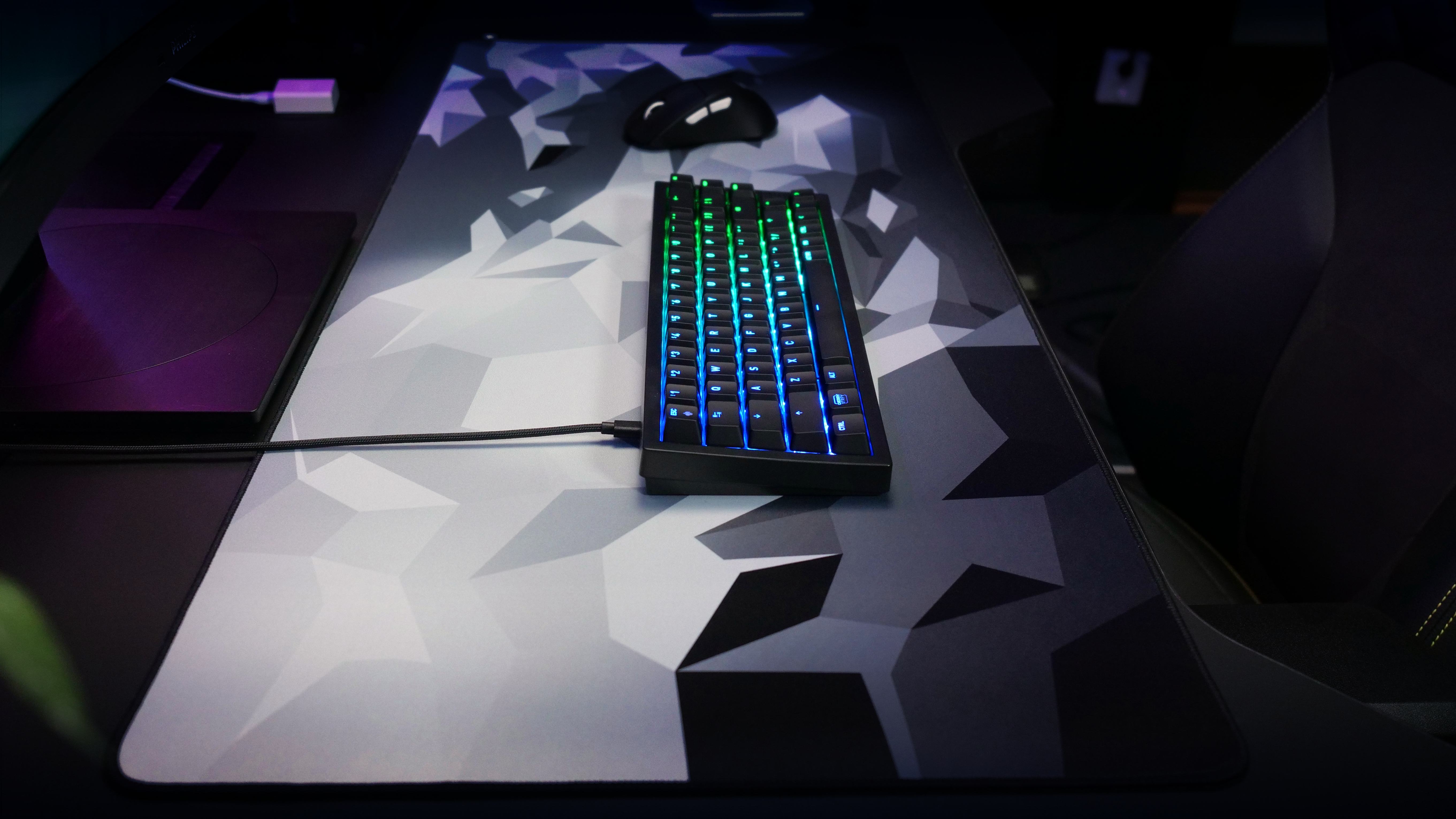 Ein Gaming-Setup mit Tastatur und Maus auf einem großen Mauspad.