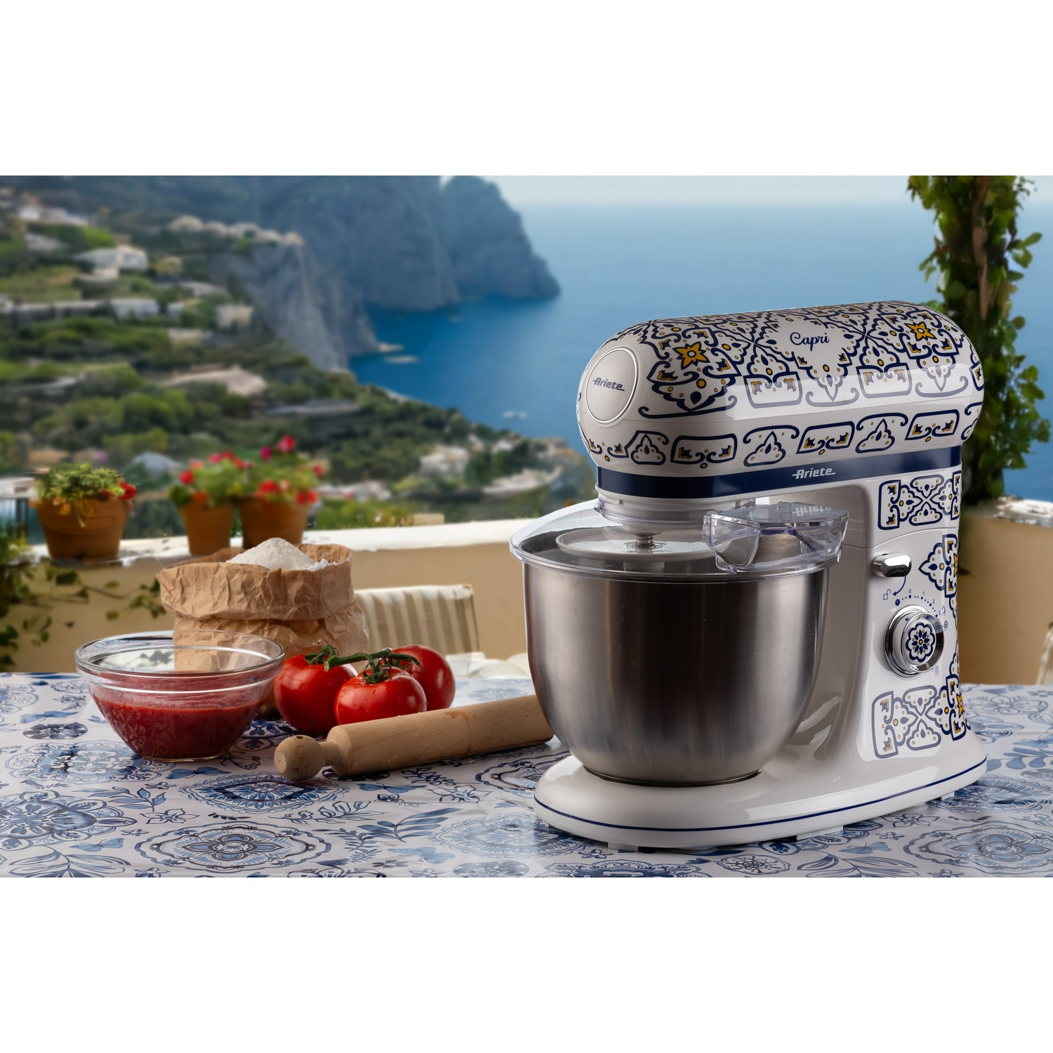 Viene mostrato un mixer da cucina con un design floreale blu su un tavolo.