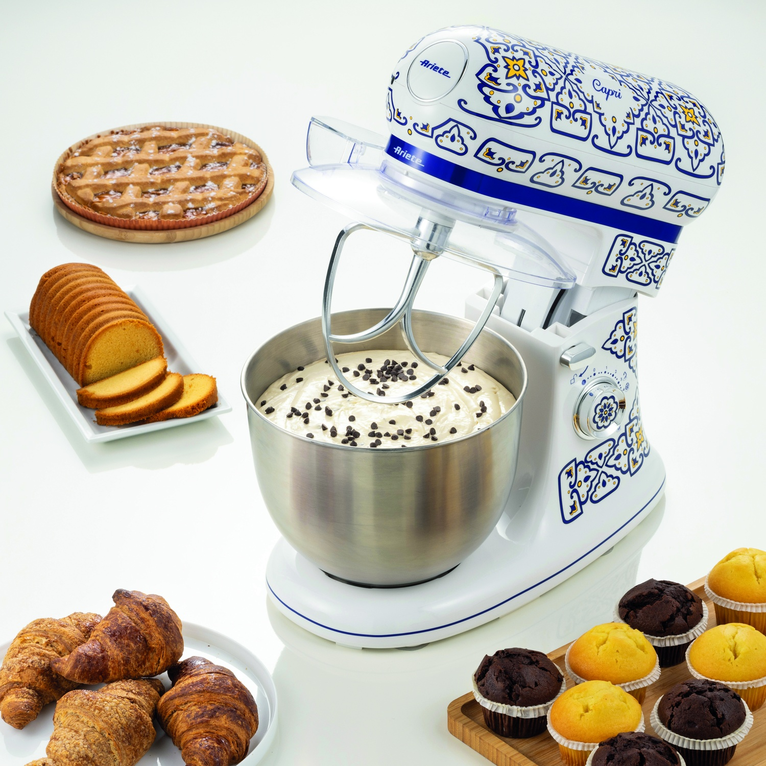 Un robot da cucina bianco e blu con pasticceria e prodotti da forno intorno.