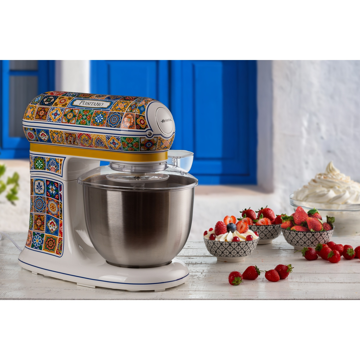 Impastatrice bianca e colorata con frutta. Ambiente cucina con fragole.