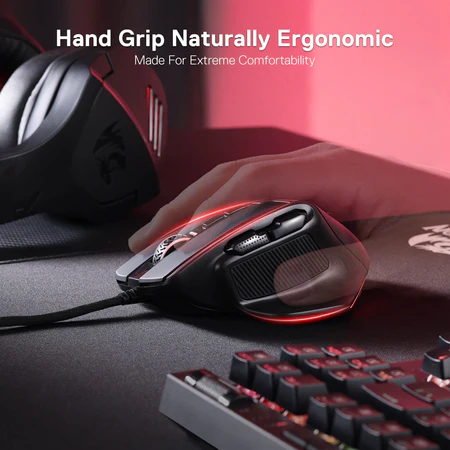 Egy kéz egy fekete gamer egeret tart. Az egér ergonomikus, piros fényekkel. Egy billentyűzet látható.