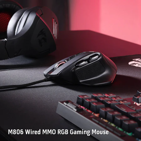 Fekete gaming egér piros részletekkel, kábellel, fekete egérpaden és billentyűzeten.