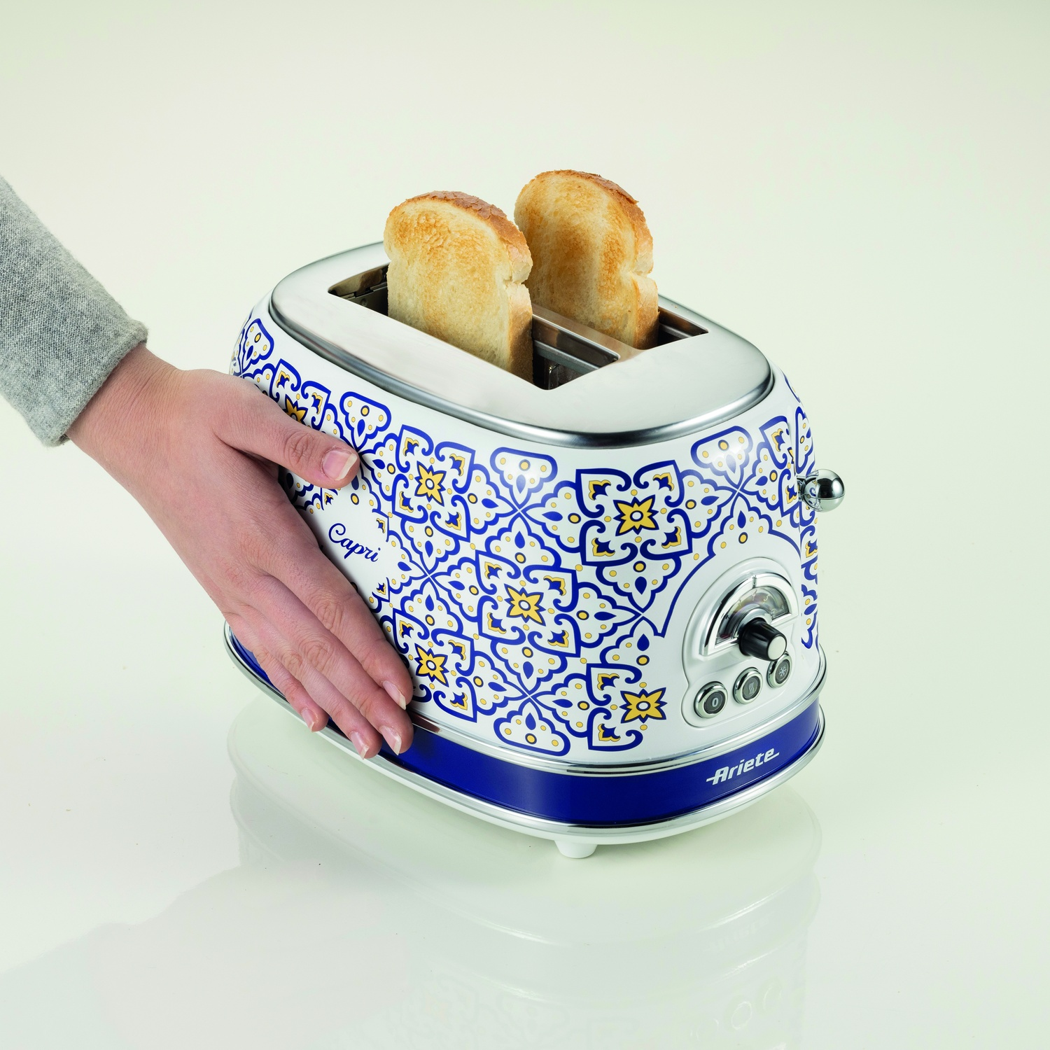Tostapane bianco e blu floreale, due fette di pane tostato dentro.