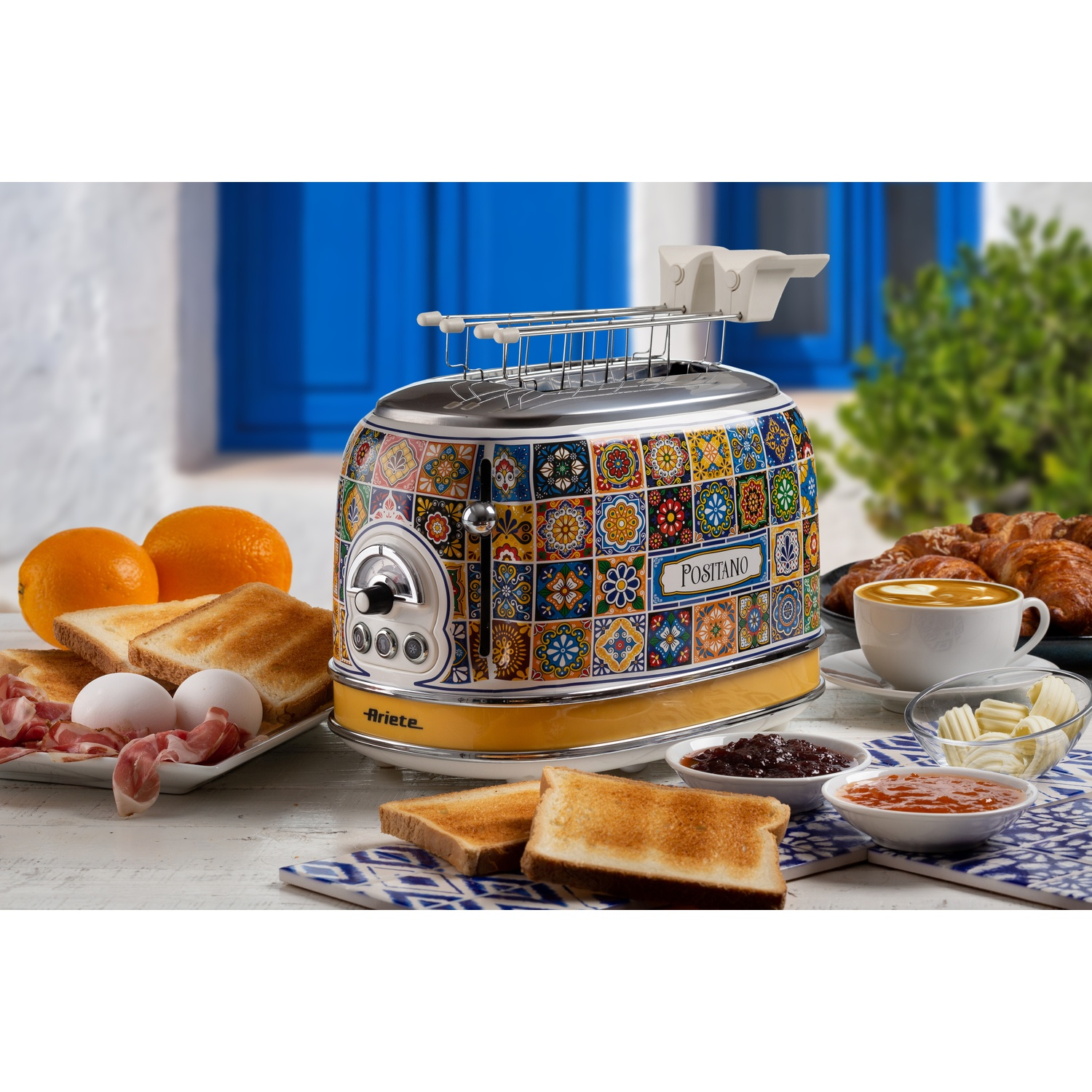 Tostapane con design a piastrelle colorate, circondato da prodotti per la colazione.