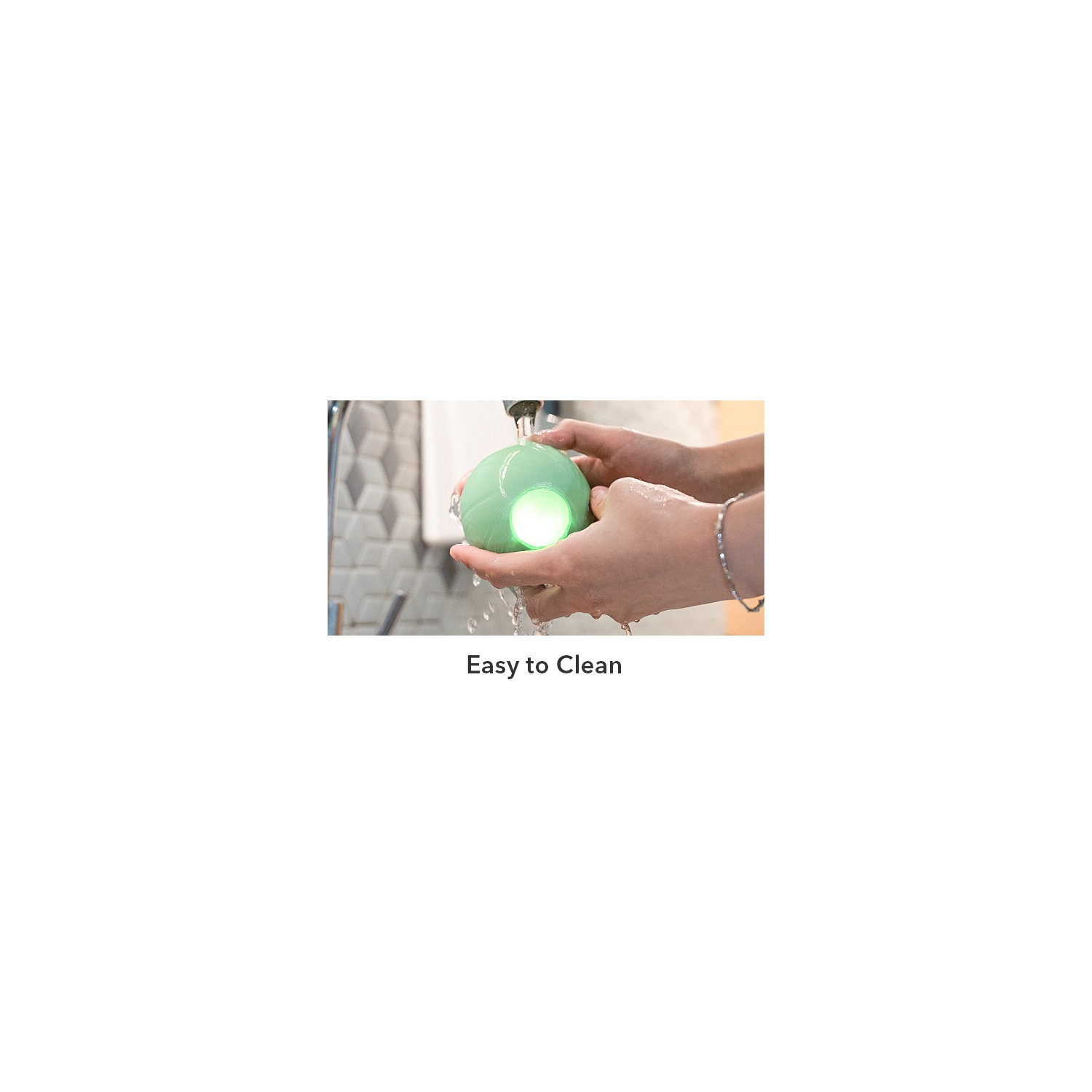 Mains lavant une boule verte et brillante sous un robinet. Texte: Easy to Clean.
