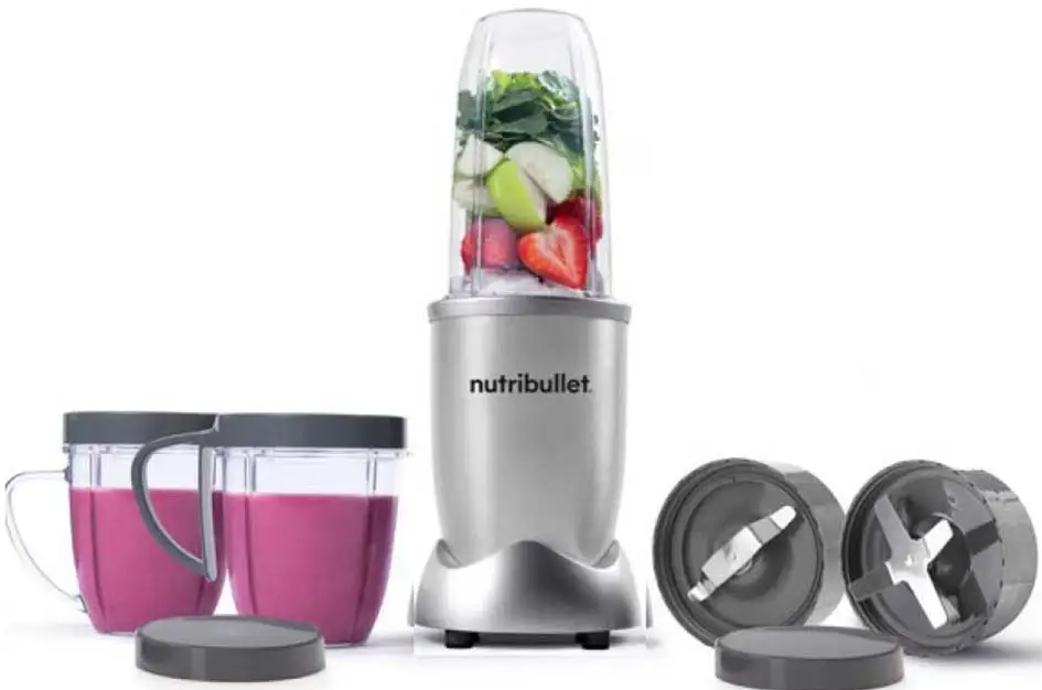 Ein silberner NutriBullet-Mixer mit Zutaten wie Früchten und zwei Bechern mit rosa Flüssigkeit.